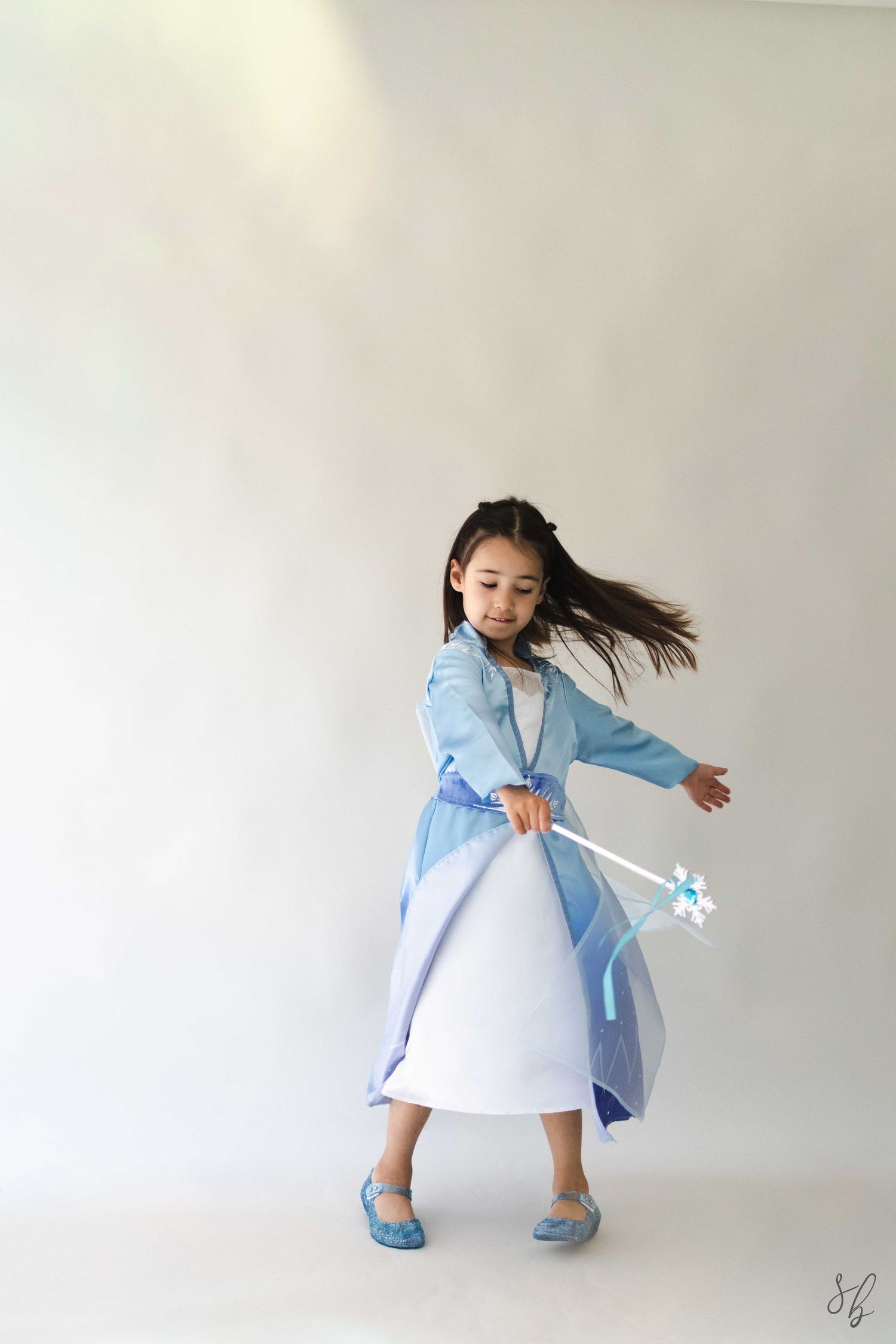 Andover children’s photographer capturing a dreamy personality portrait of a young girl in a blue princess costume and jeweled tiara.