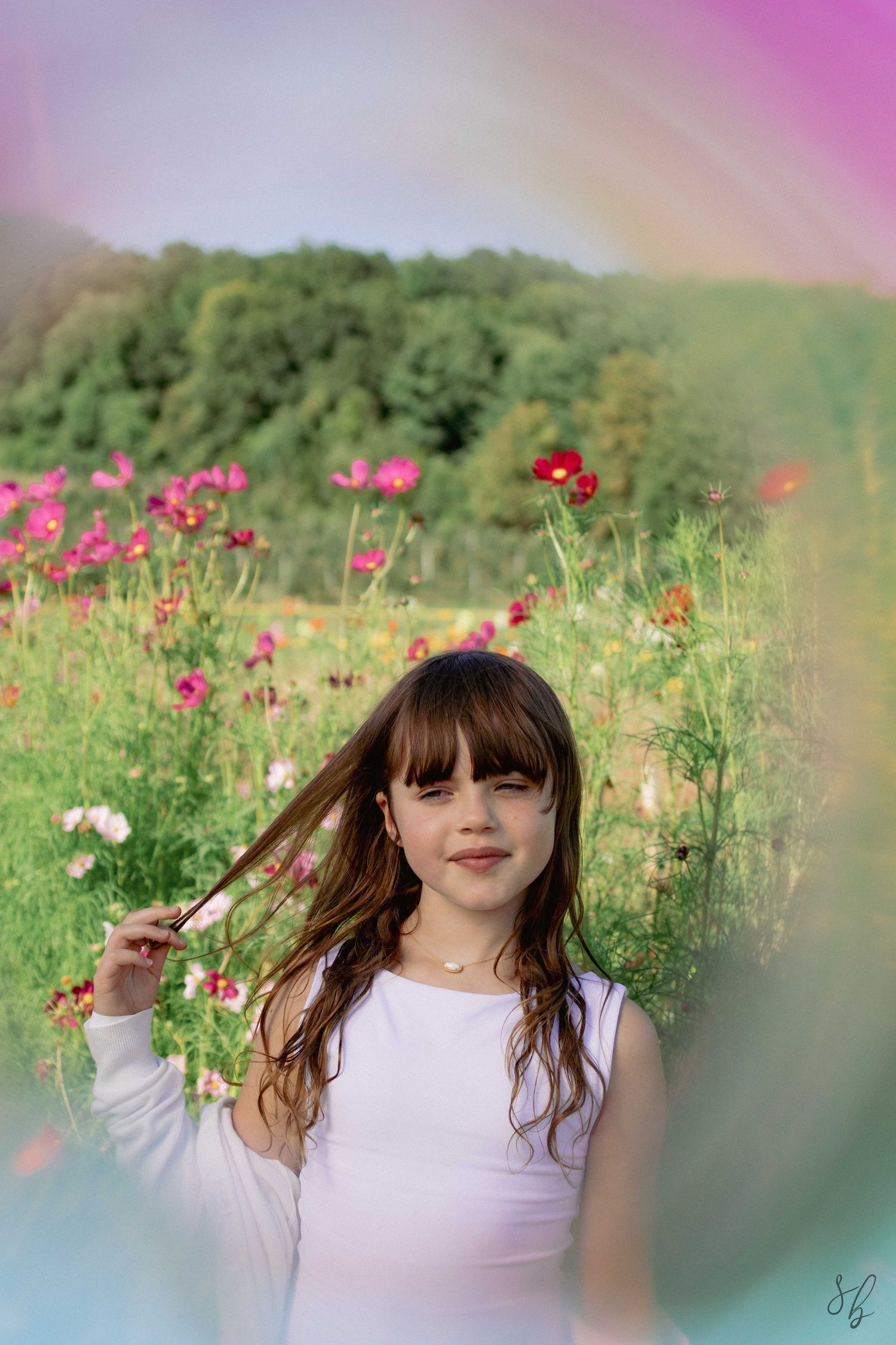 Andover children photographer capturing a natural outdoor portrait of a girl standing in a sunflower field with soft, golden light.