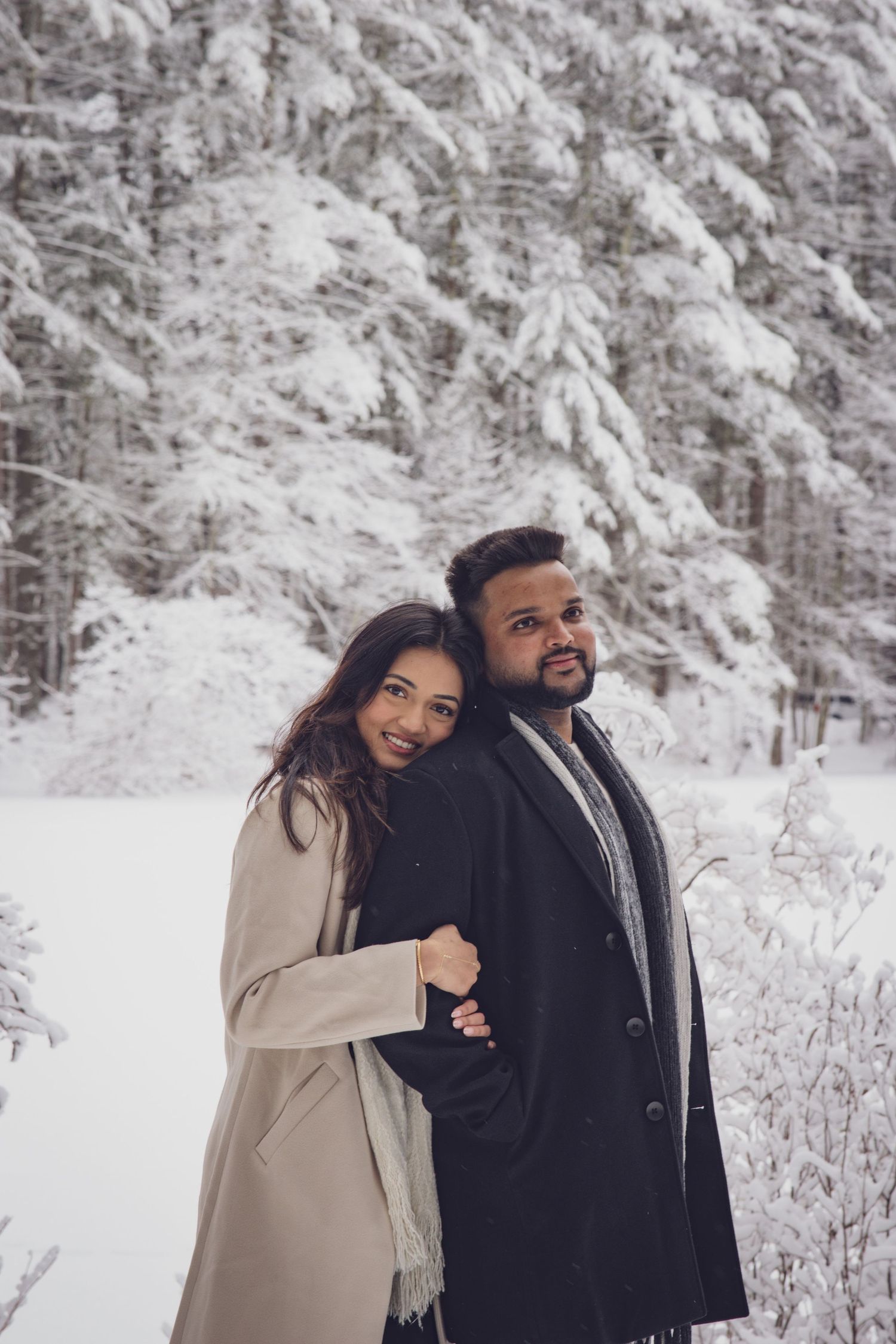 Andover couple photographer capturing a romantic winter session of a couple holding hands and walking through falling snow.