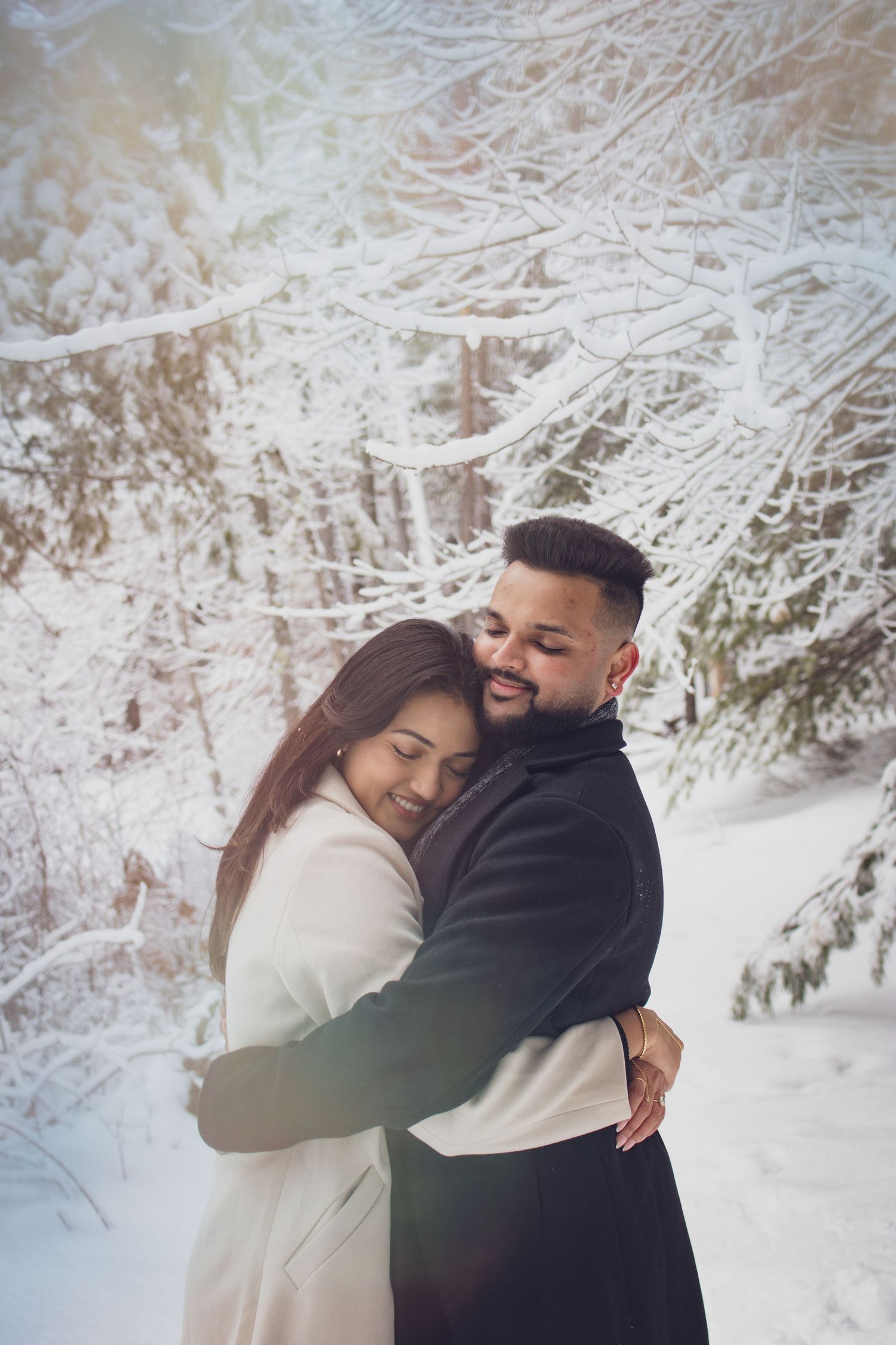 Andover couple photographer capturing a romantic winter session of a couple holding hands and walking through falling snow.
