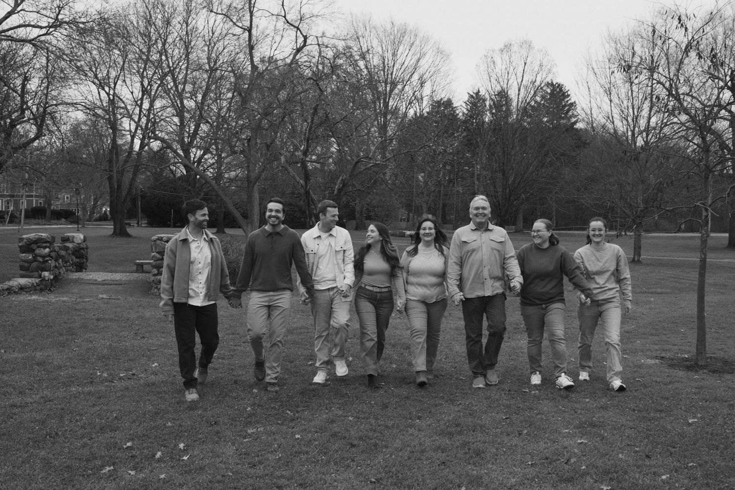 Andover family photographer capturing a candid walking moment of a family during a fall session in tall grass.