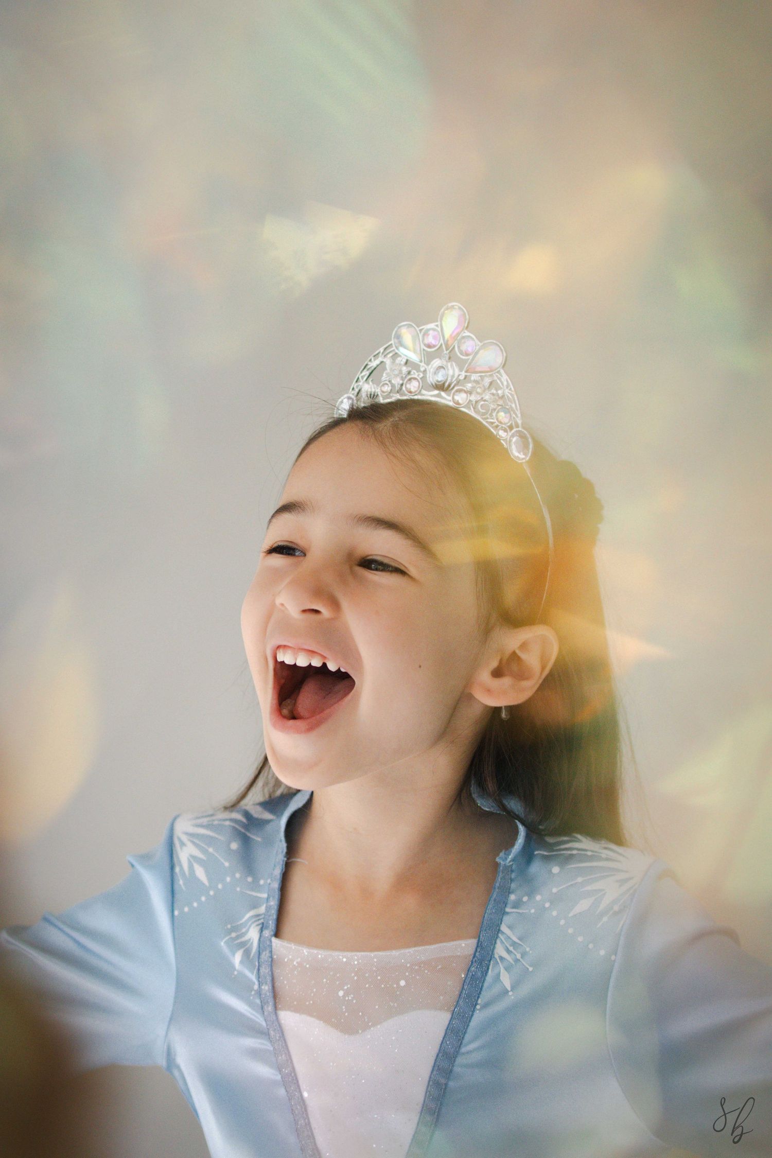 Andover children’s photographer capturing a dreamy personality portrait of a young girl in a blue princess costume and jeweled tiara.