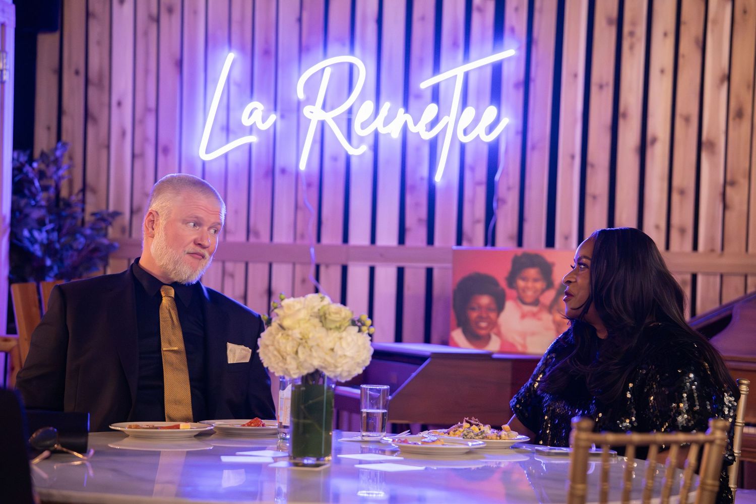 Two guests dining at La Renetee restaurant, seated at an elegantly set table with white floral centerpiece.