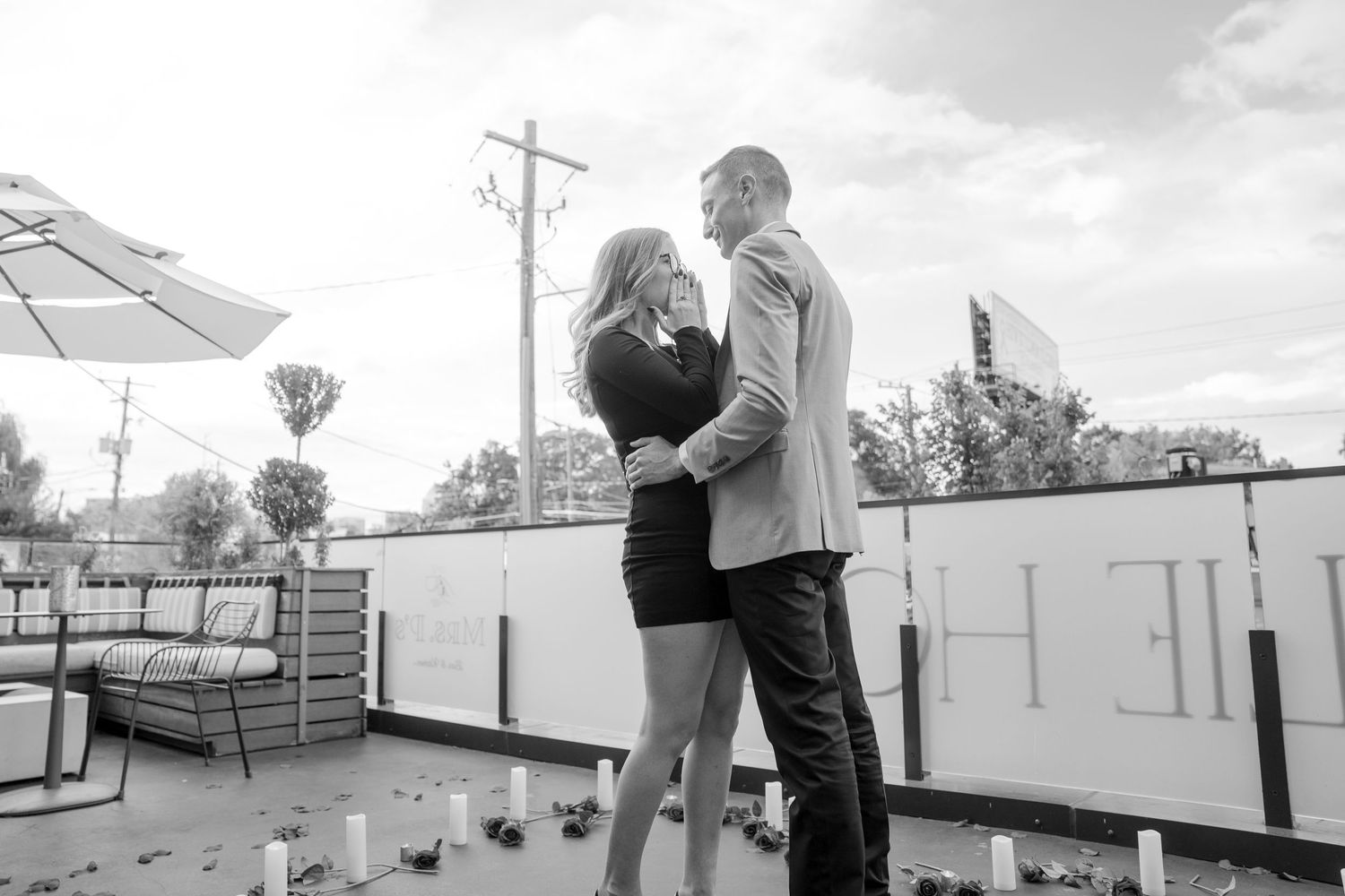 Couple sharing an intimate moment on a rooftop setting.