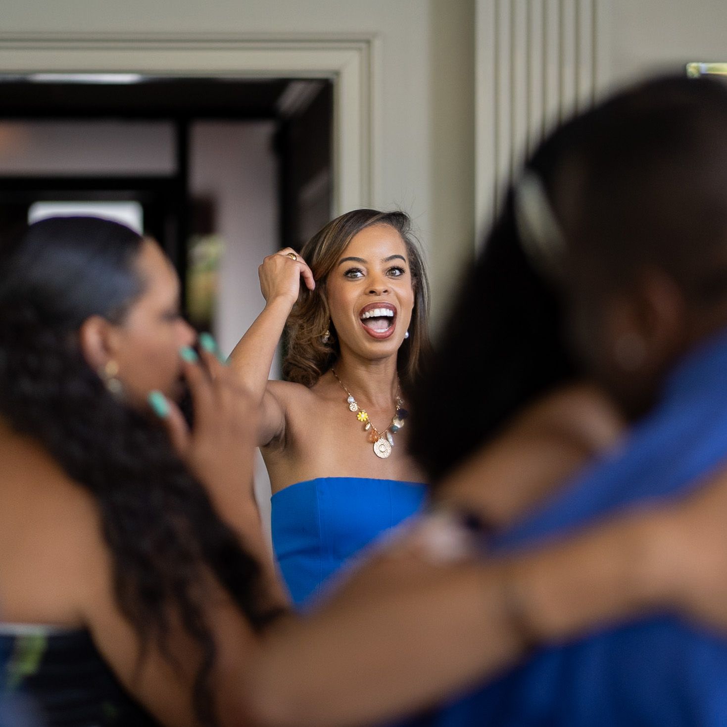 Wedding party members in blue dresses share joyful moments during celebration.