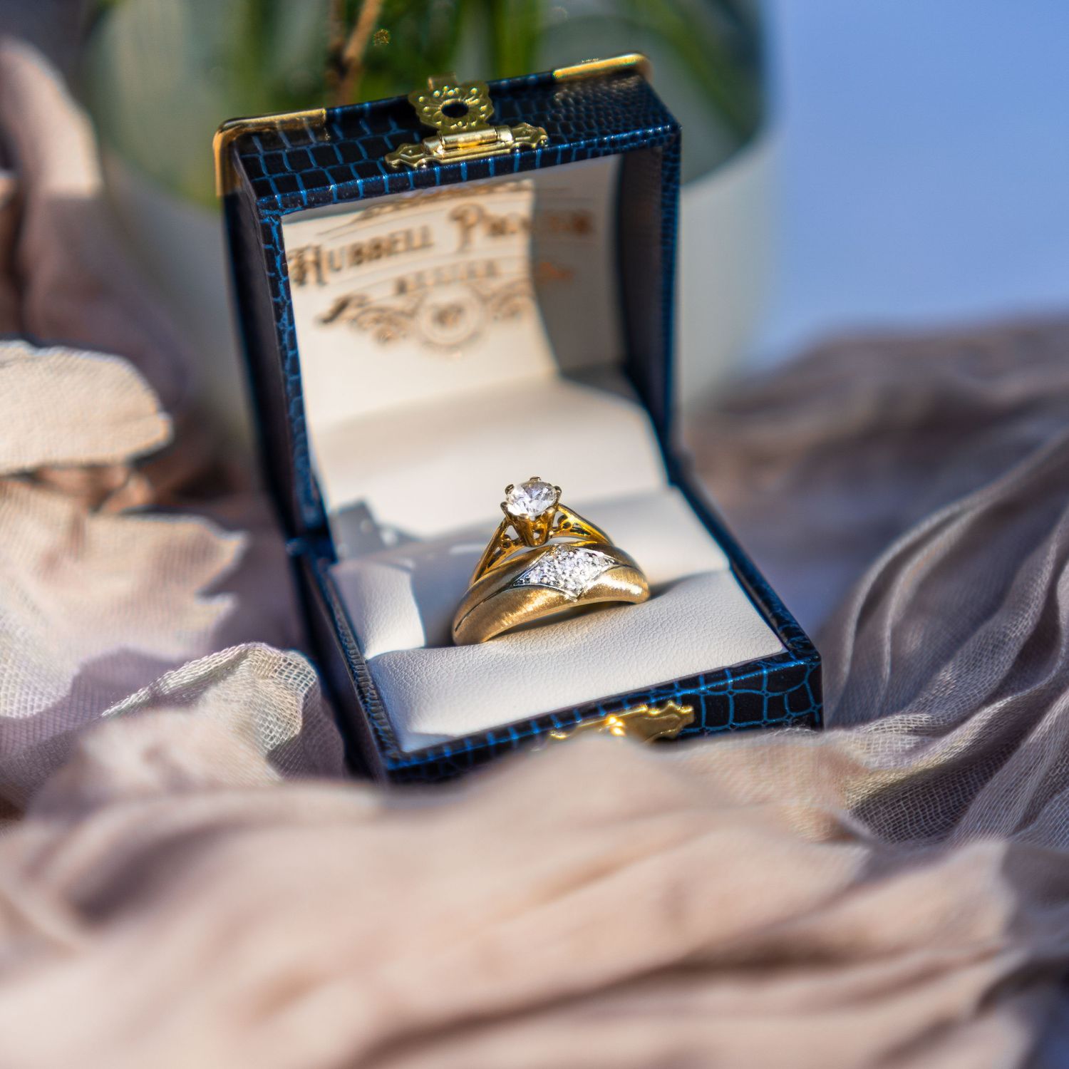 A diamond engagement ring displayed in a navy blue velvet box.