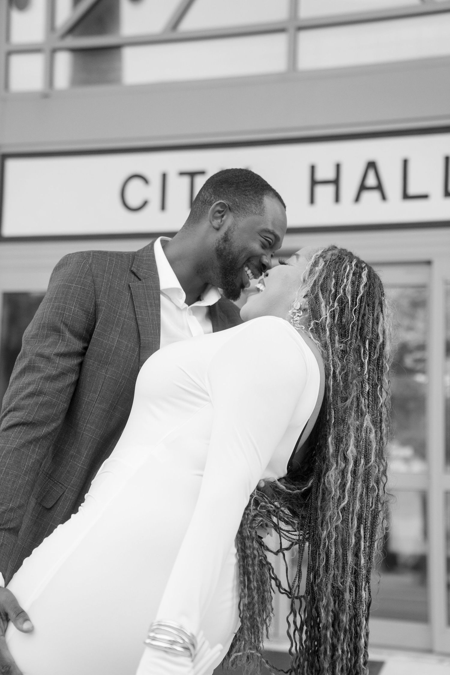 Black and white photo series outside city hall showing couple's emotional moments.