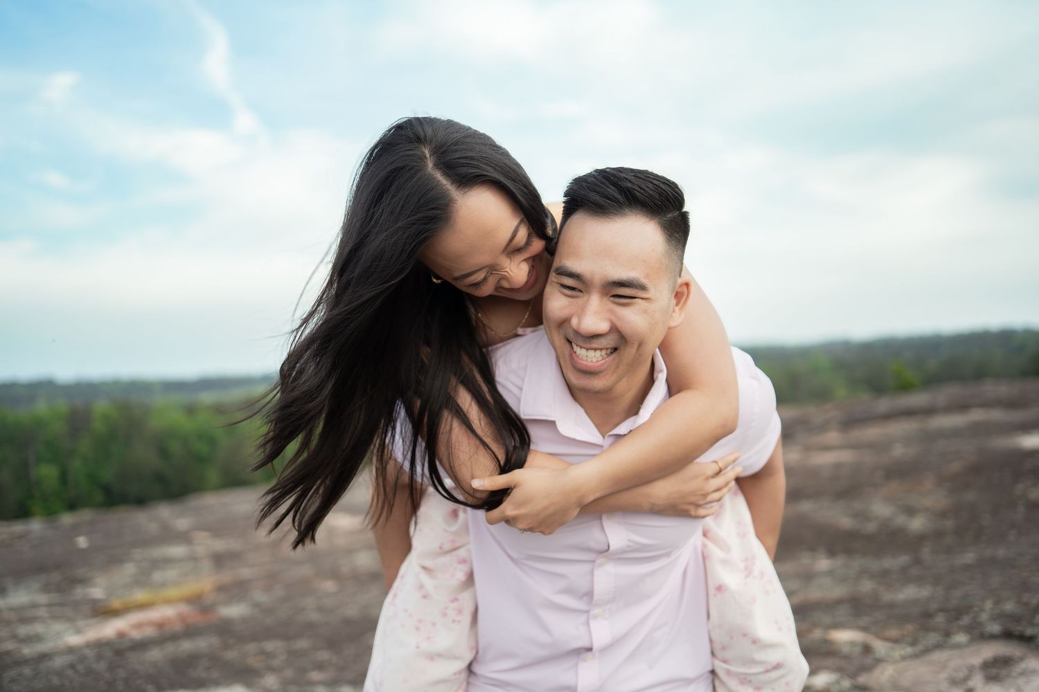 Playful engagement session photos in casual attire against a natural landscape.