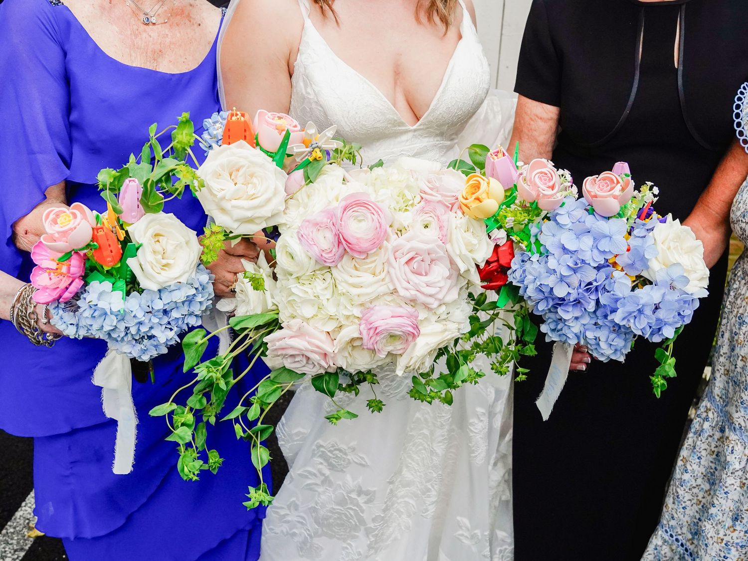 Bridesmaids holding elegant bouquets of pink, white and blue flowers.