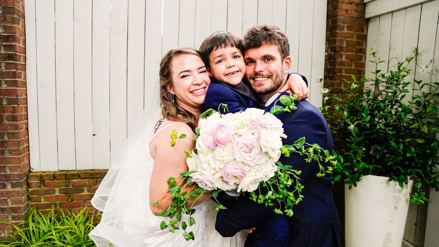 A series of romantic wedding photos showing a couple posing against a brick wall and white siding.