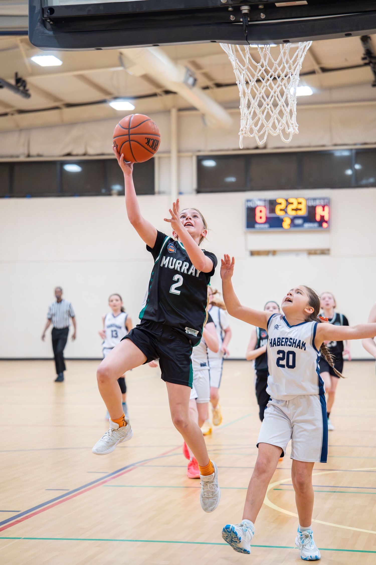 Young girl in Murray #2 jersey attempts a layup during a youth basketball game against Habersham team.