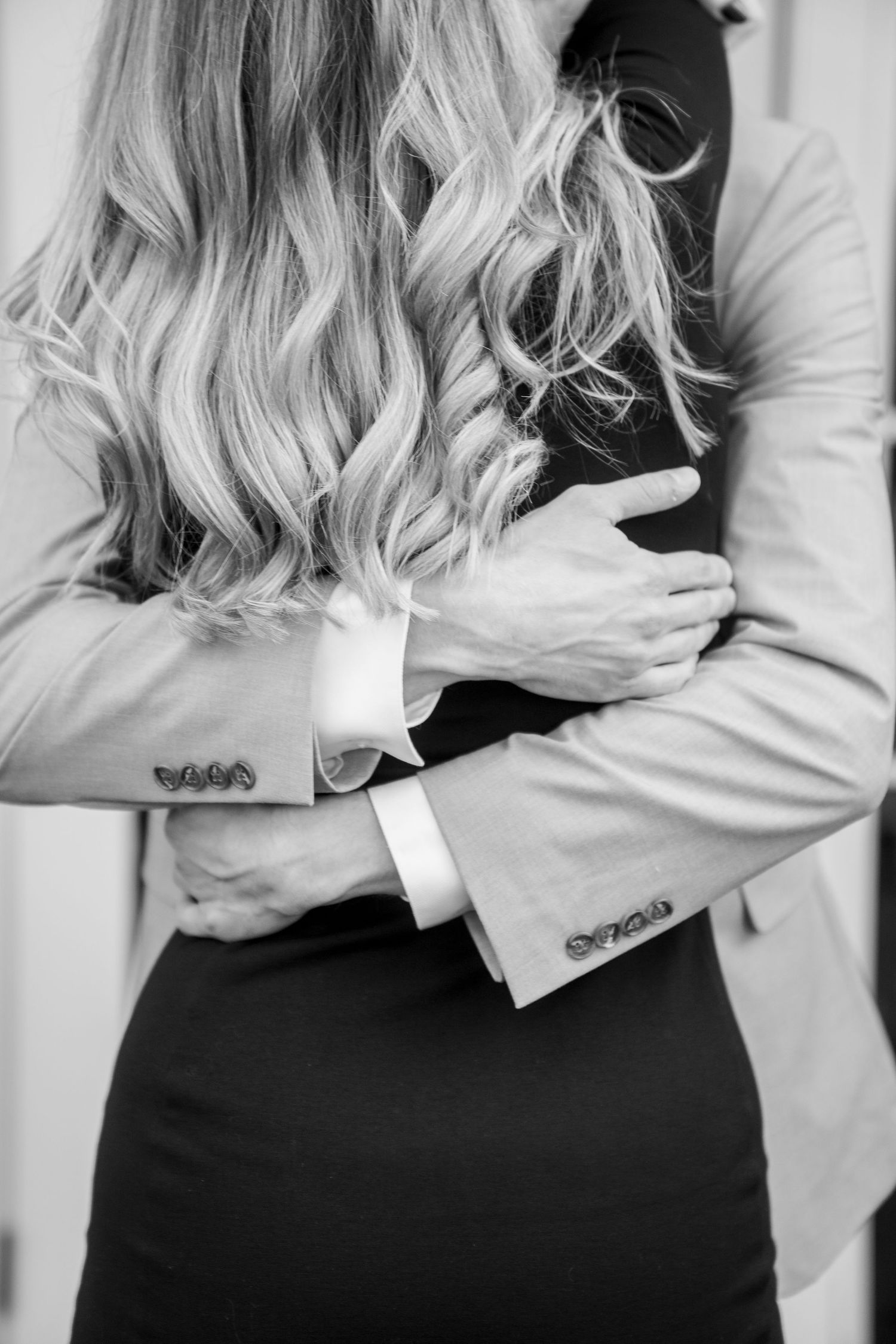 Black and white close-up of an intimate embrace showing formal attire.