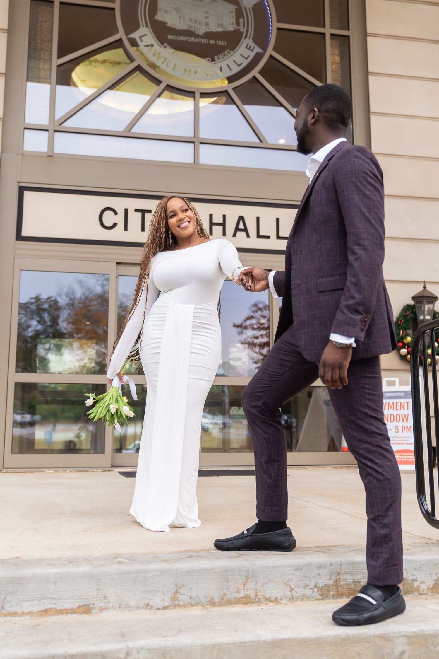 A series of wedding photos captured at the entrance of a city hall building.