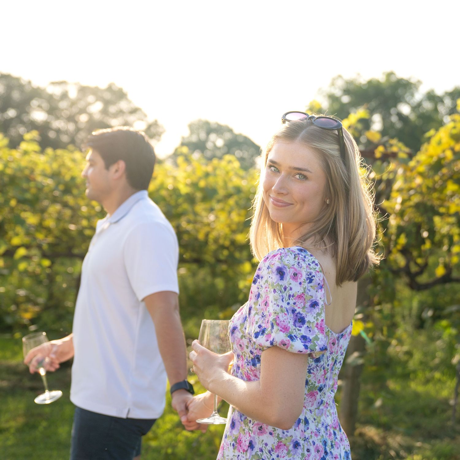 Couple dancing in golden sunlight with floral dress details visible.