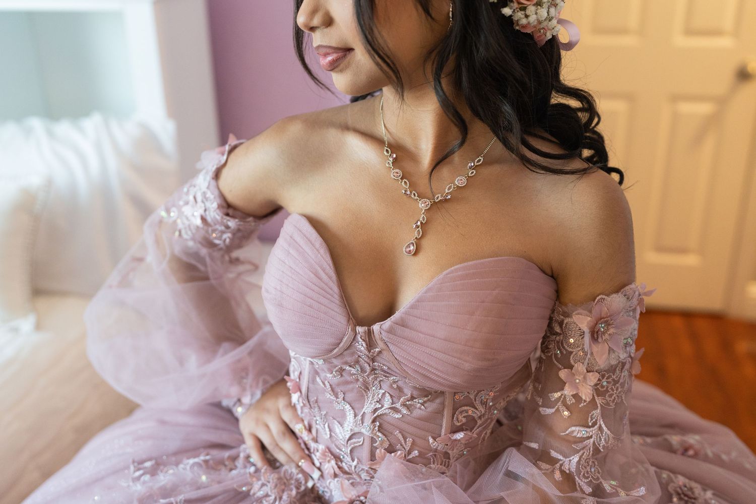 Close-up of quinceañera girl in lavender off-shoulder gown wearing diamond necklace.