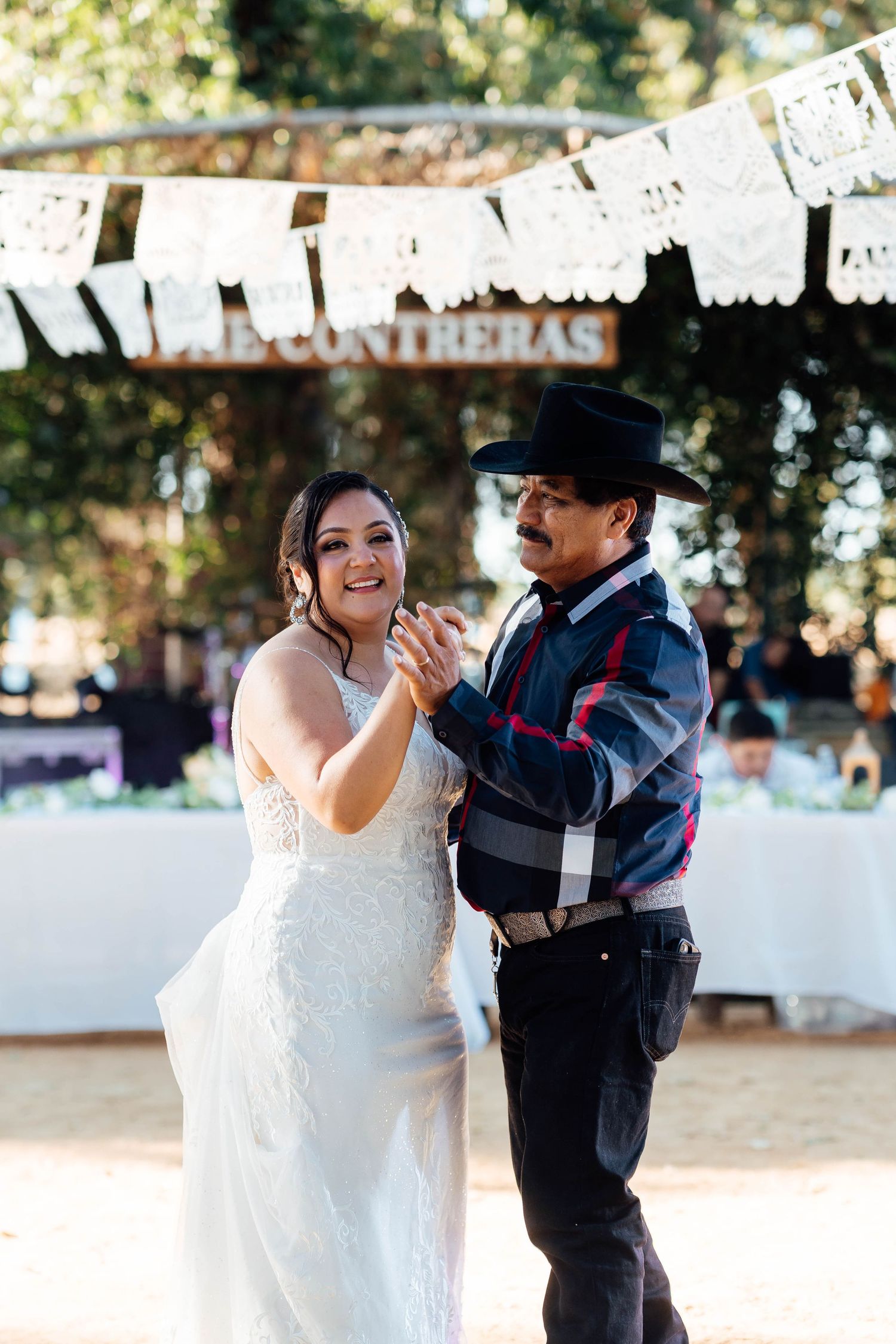 Bride dances with father under papel picado at The Contreras wedding reception.