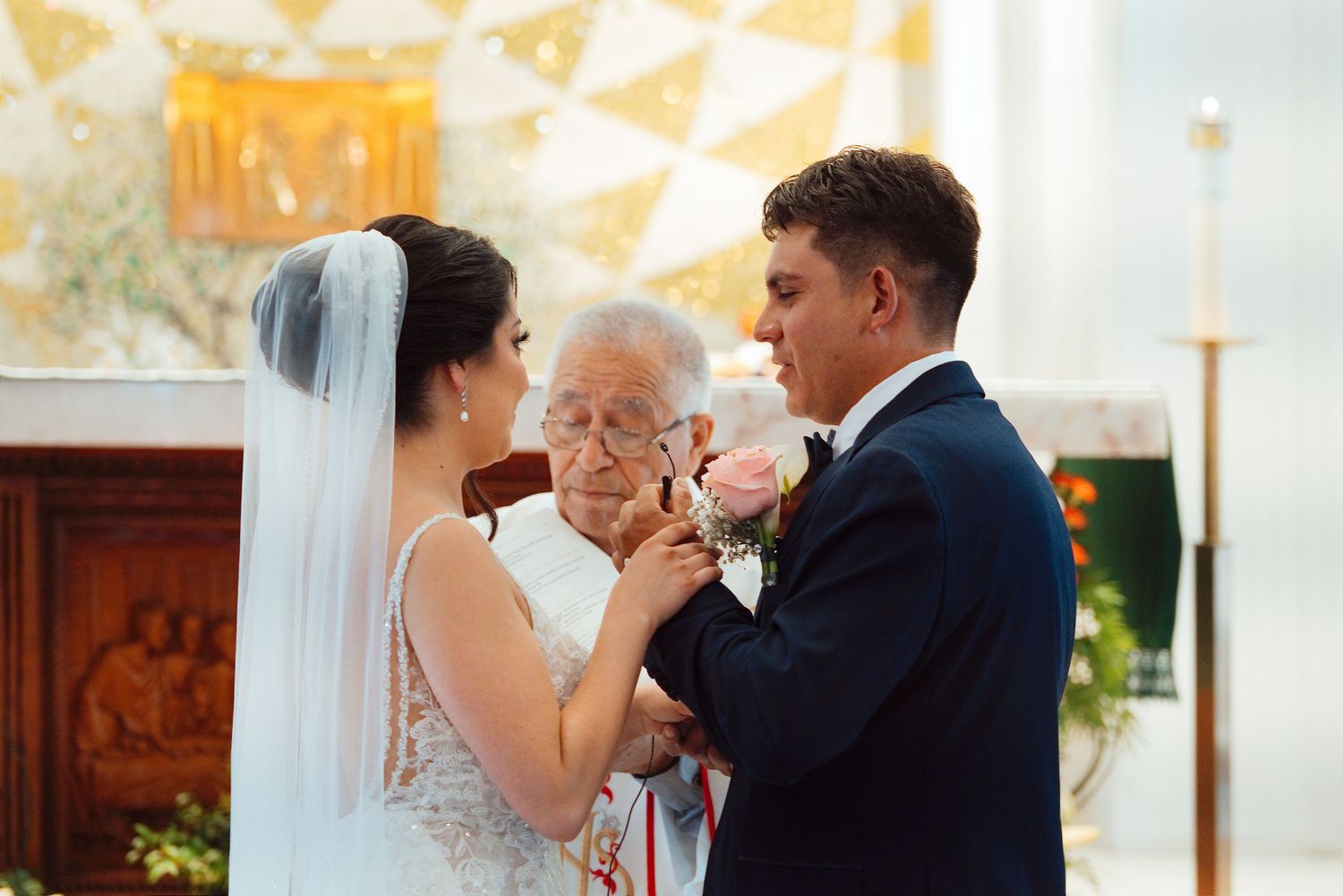 Elderly woman blessing newlywed couple during wedding ceremony inside a church.