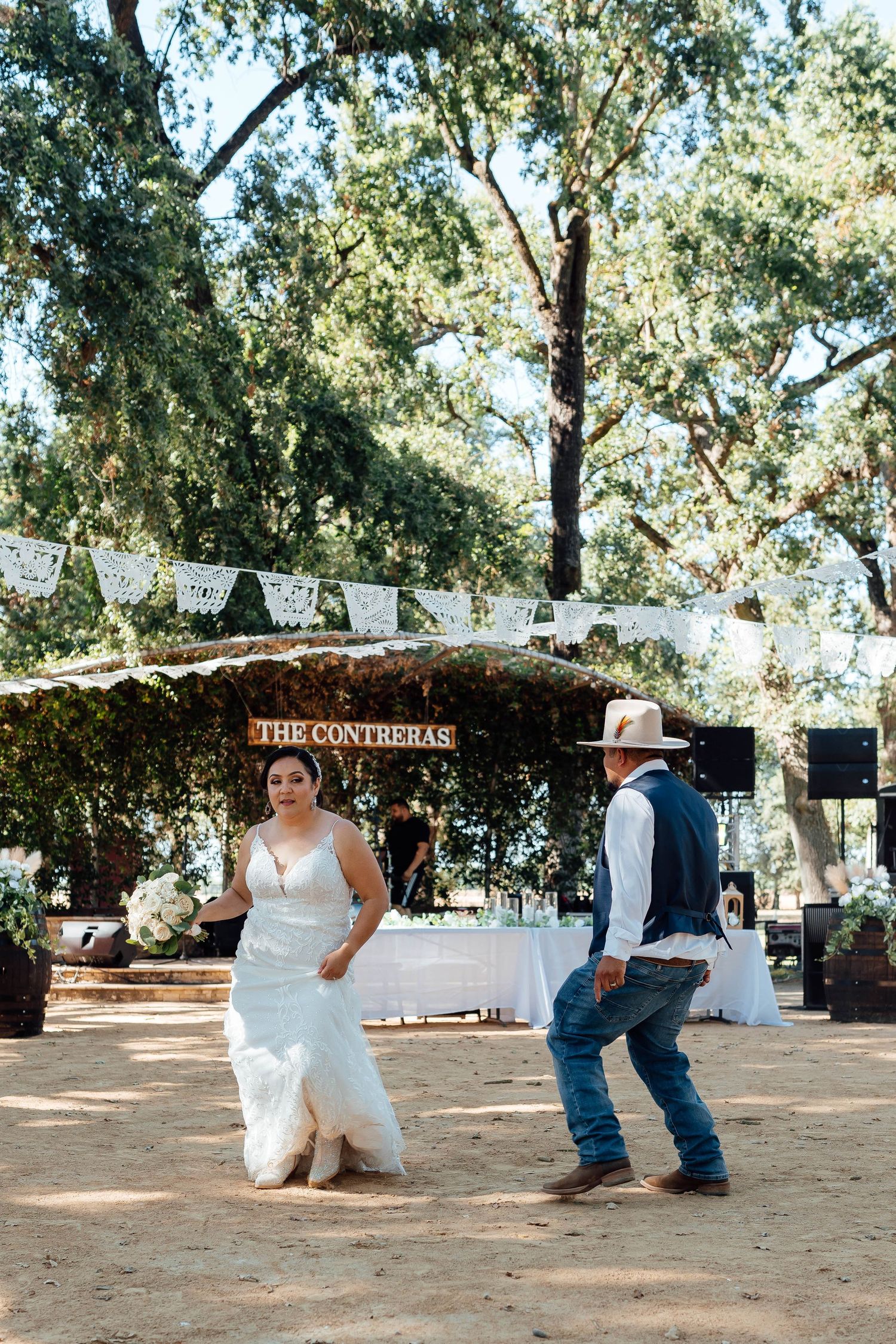 Bride and groom share first dance outdoors under The Contreras wedding sign.