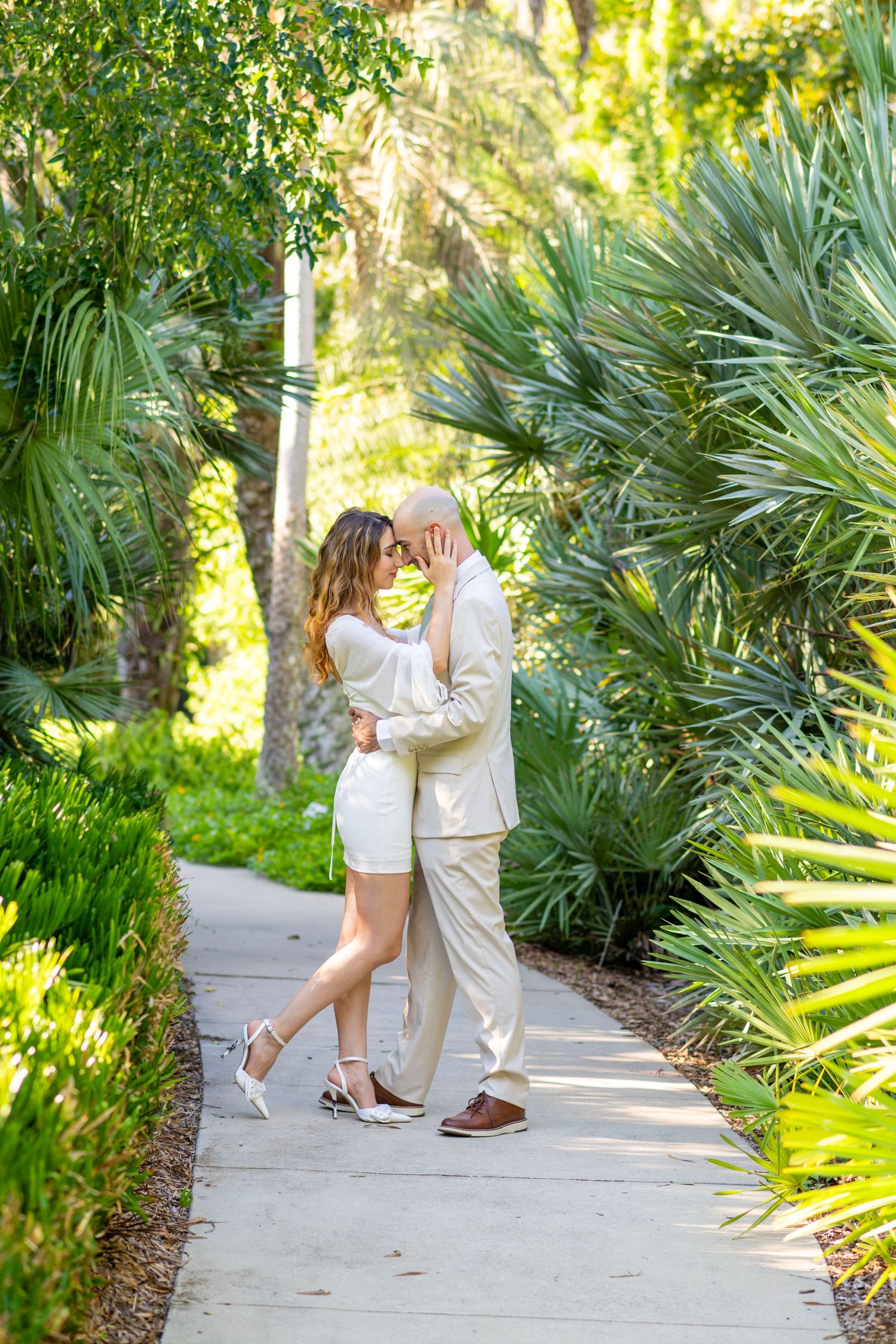 couples poses facing each other with fore head together for engagement photos inside Kanapaha botanical gardens in Gainesville florida
