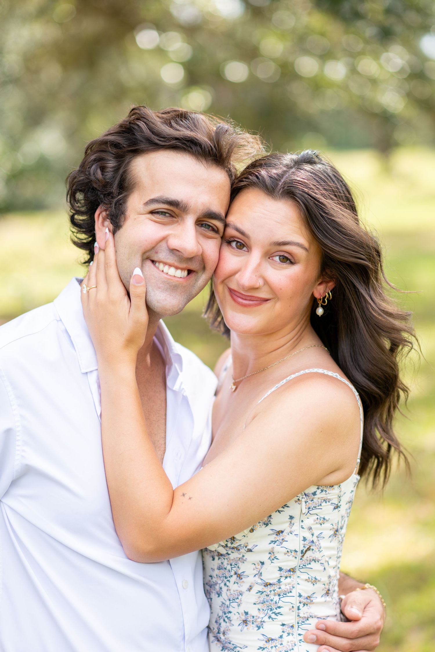 couples poses for engagement photos with head close together in field at sunset in hunters creek florida