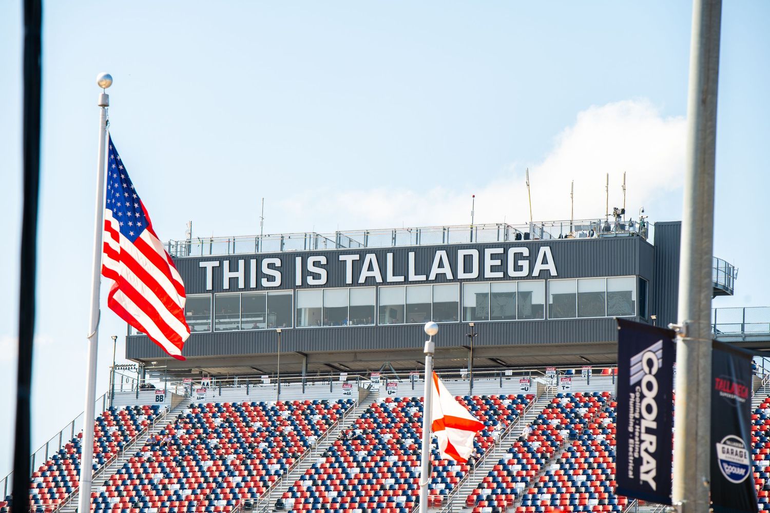 American flag flies in front of Talladega Superspeedway grandstand sign reading This Is Talladega.