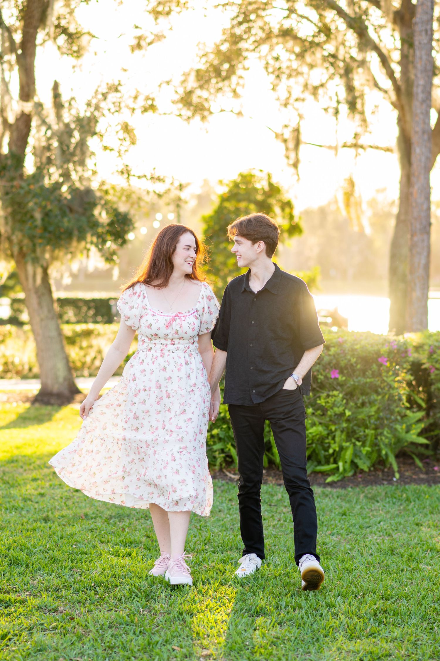 couples holding hands walking looking at each other in celebration Florida for engagement photos