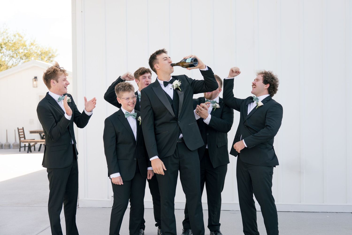 Groomsmen cheering on the groom at White Dove Barn