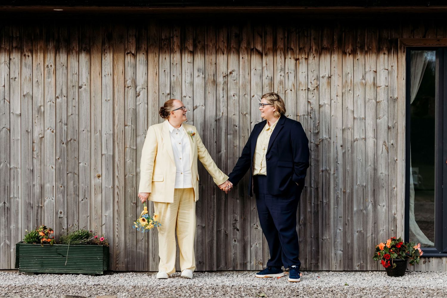 Rustic wedding portraits outside wooden barn exterior with natural lighting and minimalist design in Rossendale, Lancashire.