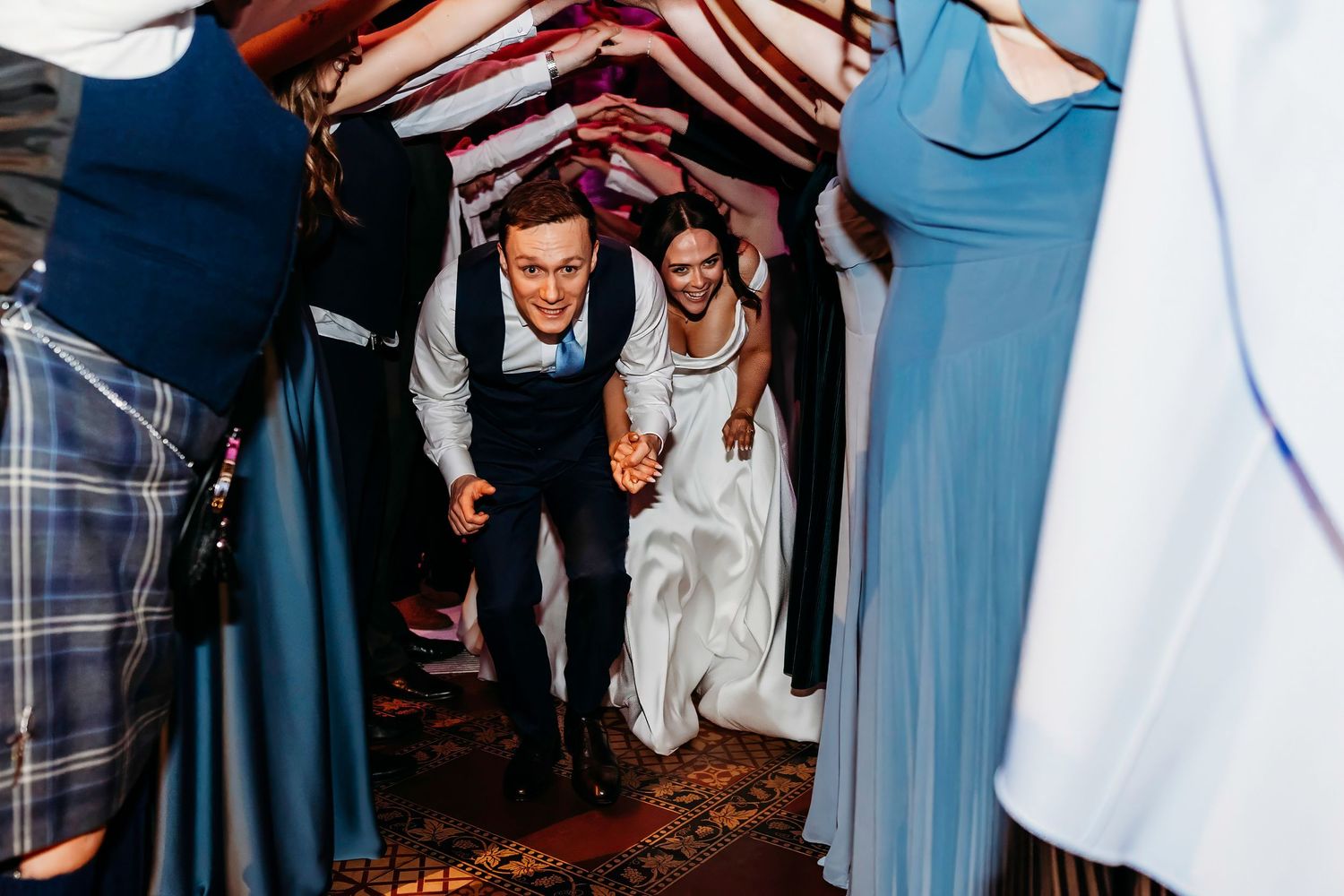 Wedding guests dancing and celebrating on a crowded dance floor at Peckforton Castle Wedding, Cheshire.