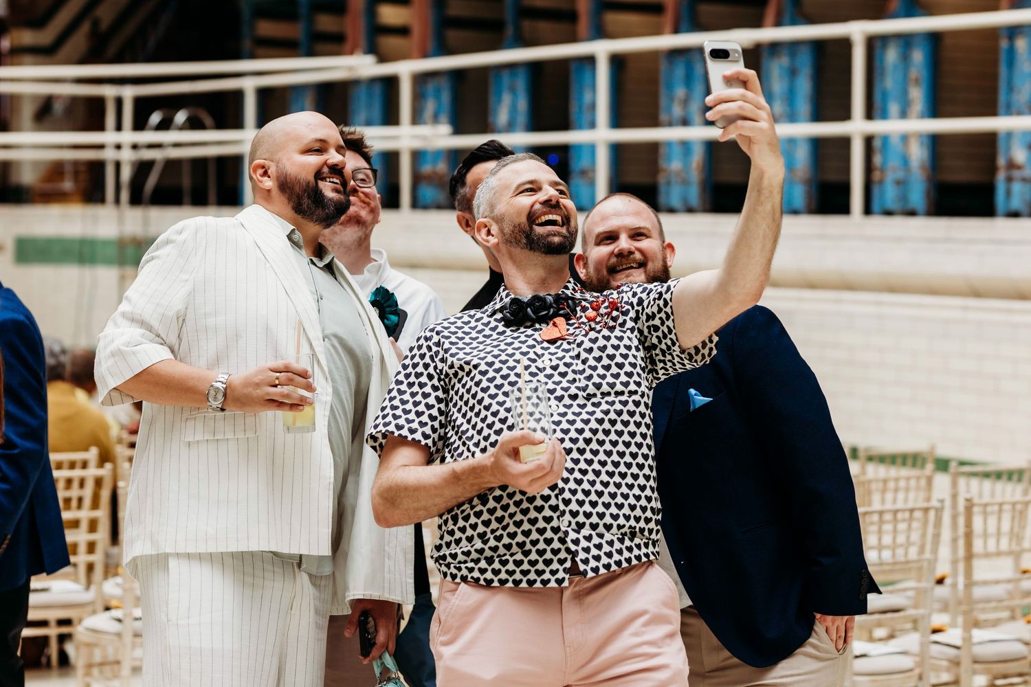A group celebrates joyfully at a wedding reception at the iconic Victoria Baths venue in Manchester.