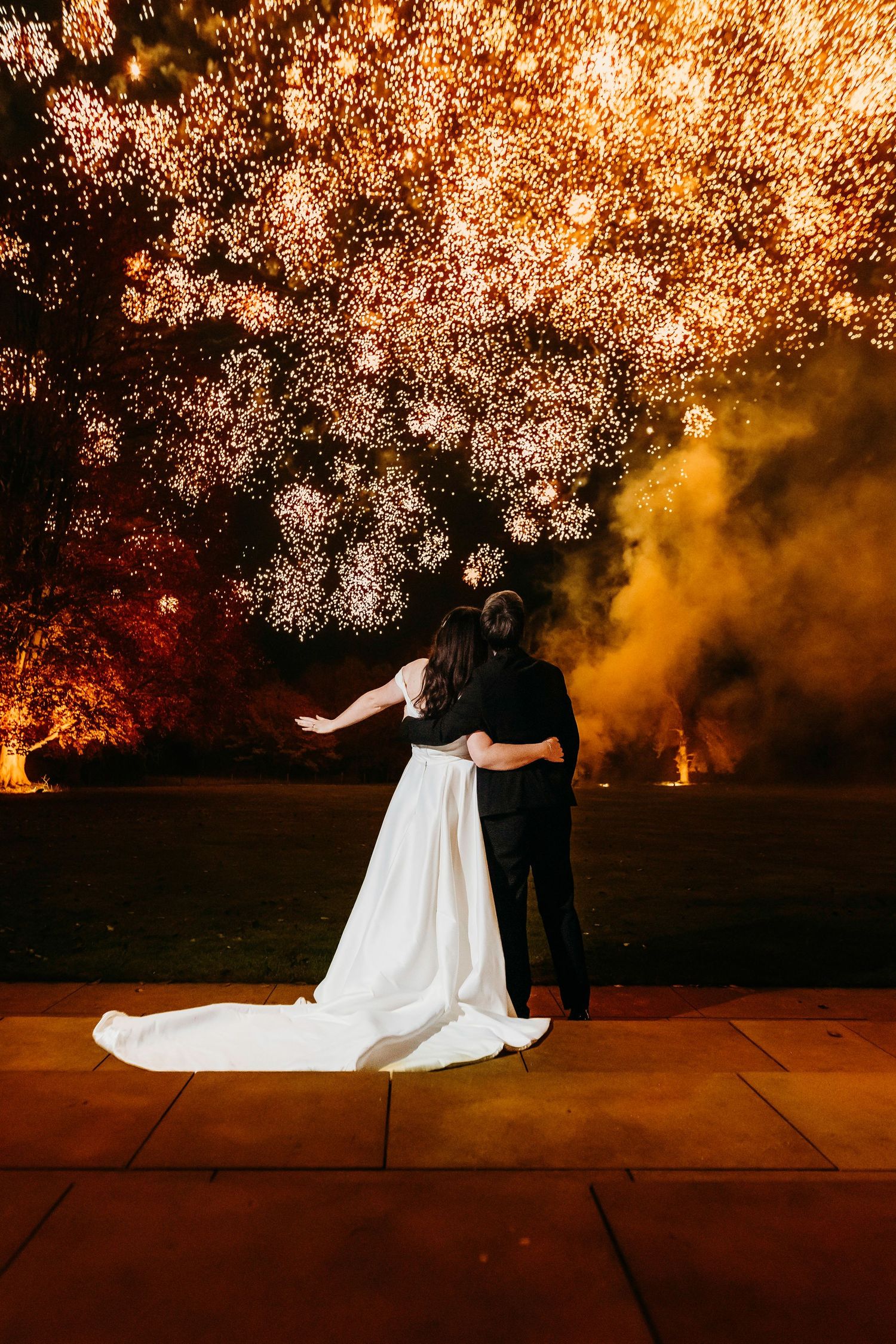 Dramatic nighttime wedding photo with fireworks creating a magical outdoor atmosphere at Burtonfields Hall historic wedding venue, York.