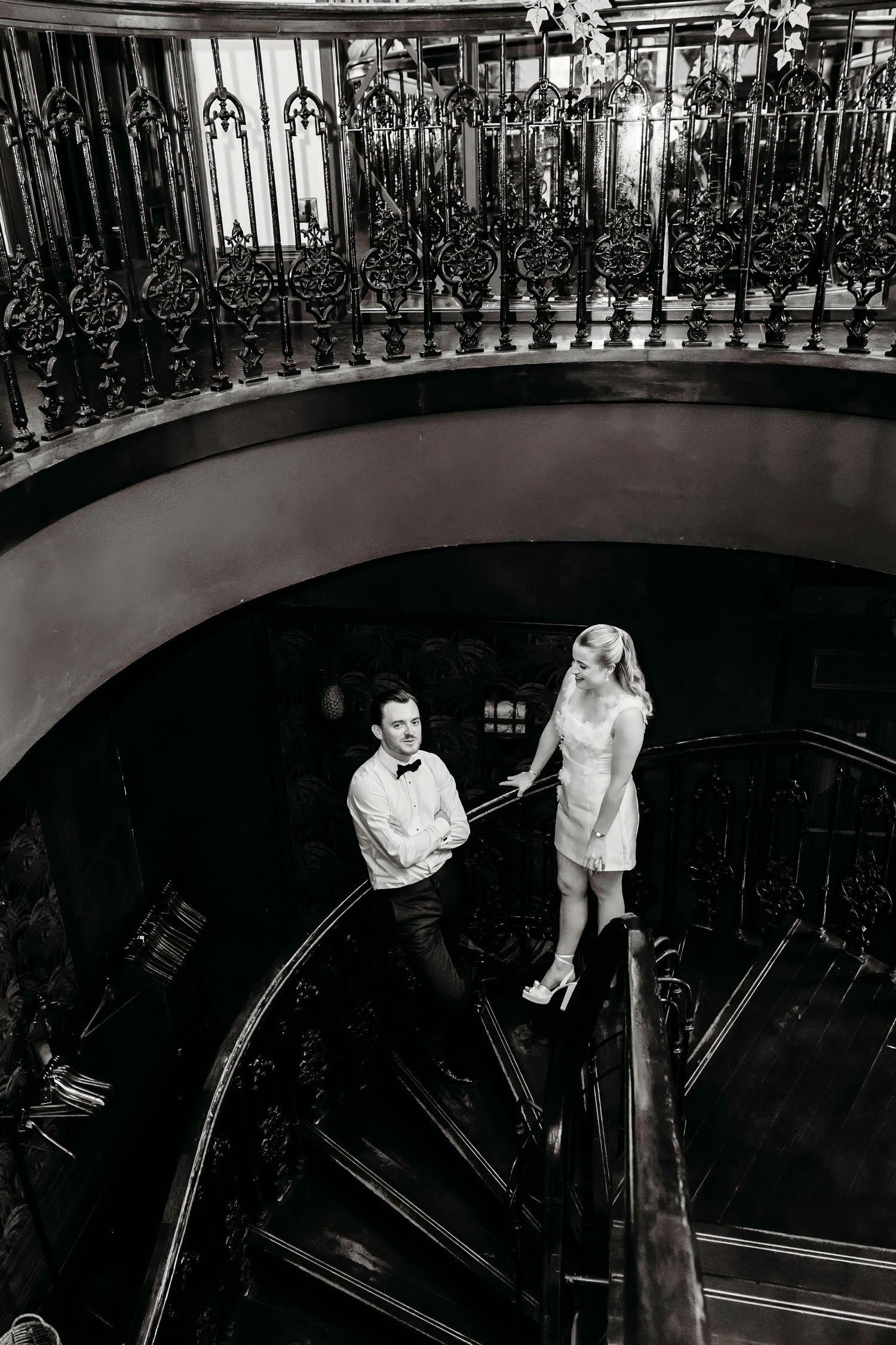 Black and white architectural wedding photo featuring ornate iron railings and dramatic angles at Grand Pacific, Manchester.