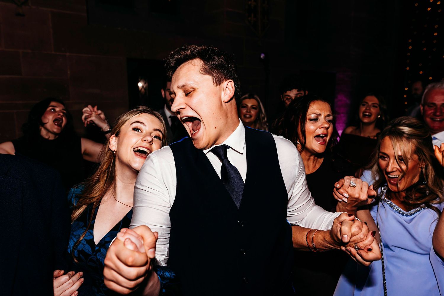Wedding reception guests dancing and celebrating at Peckforton Castle, Cheshire.