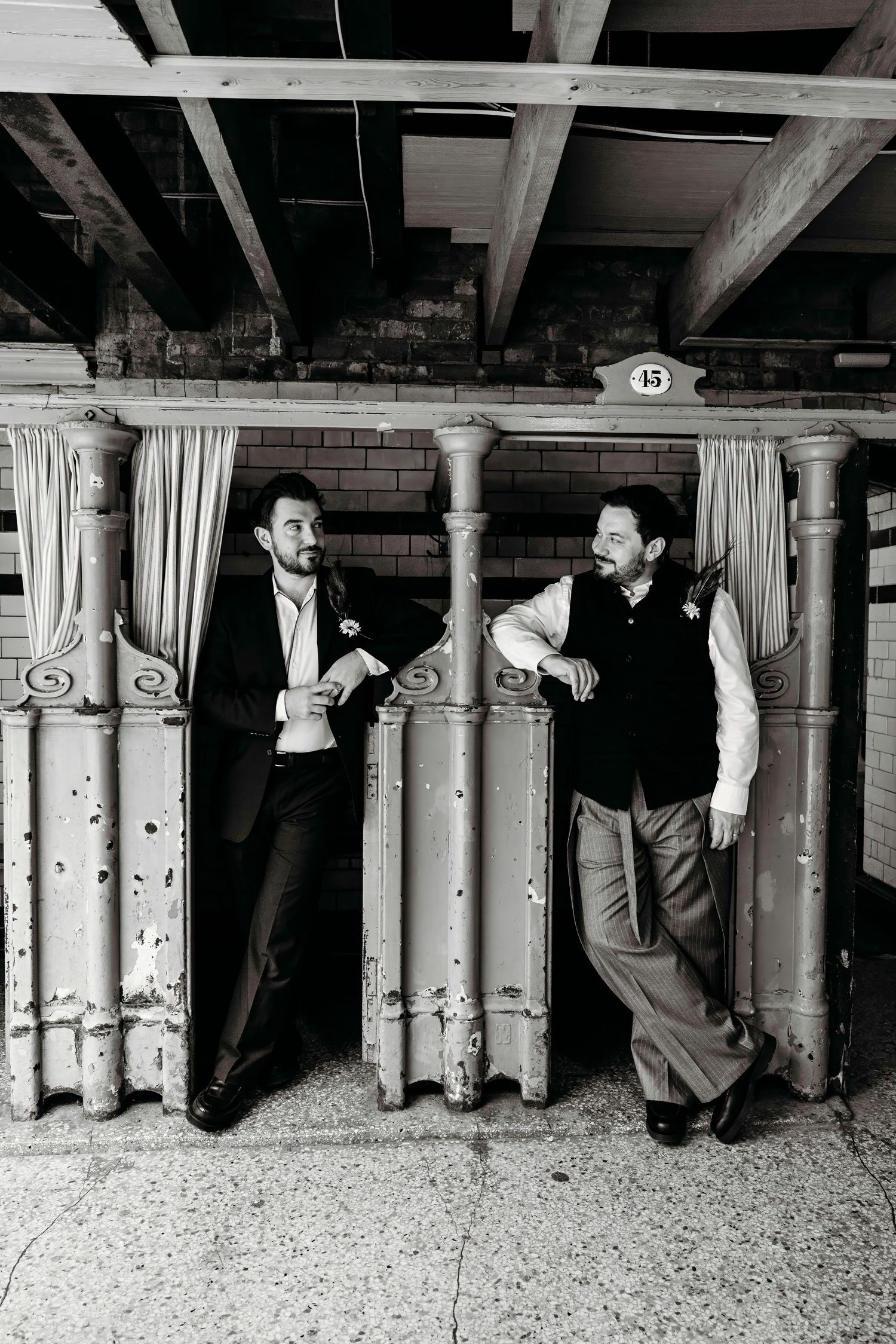 Creative black and white photo sequence showing grooms hiding behind changing stalls at the iconic Victoria Baths, Manchester.