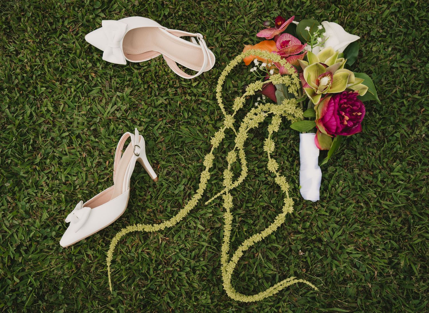 Wedding decorations and flowers arranged on green grass.