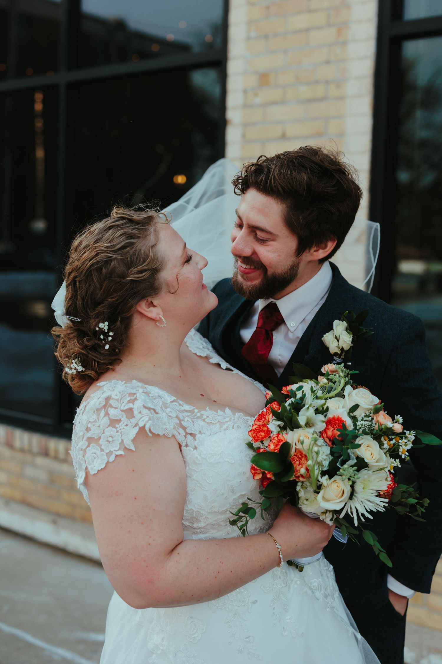 Romantic outdoor portraits of newlyweds sharing intimate moments with floral bouquet.