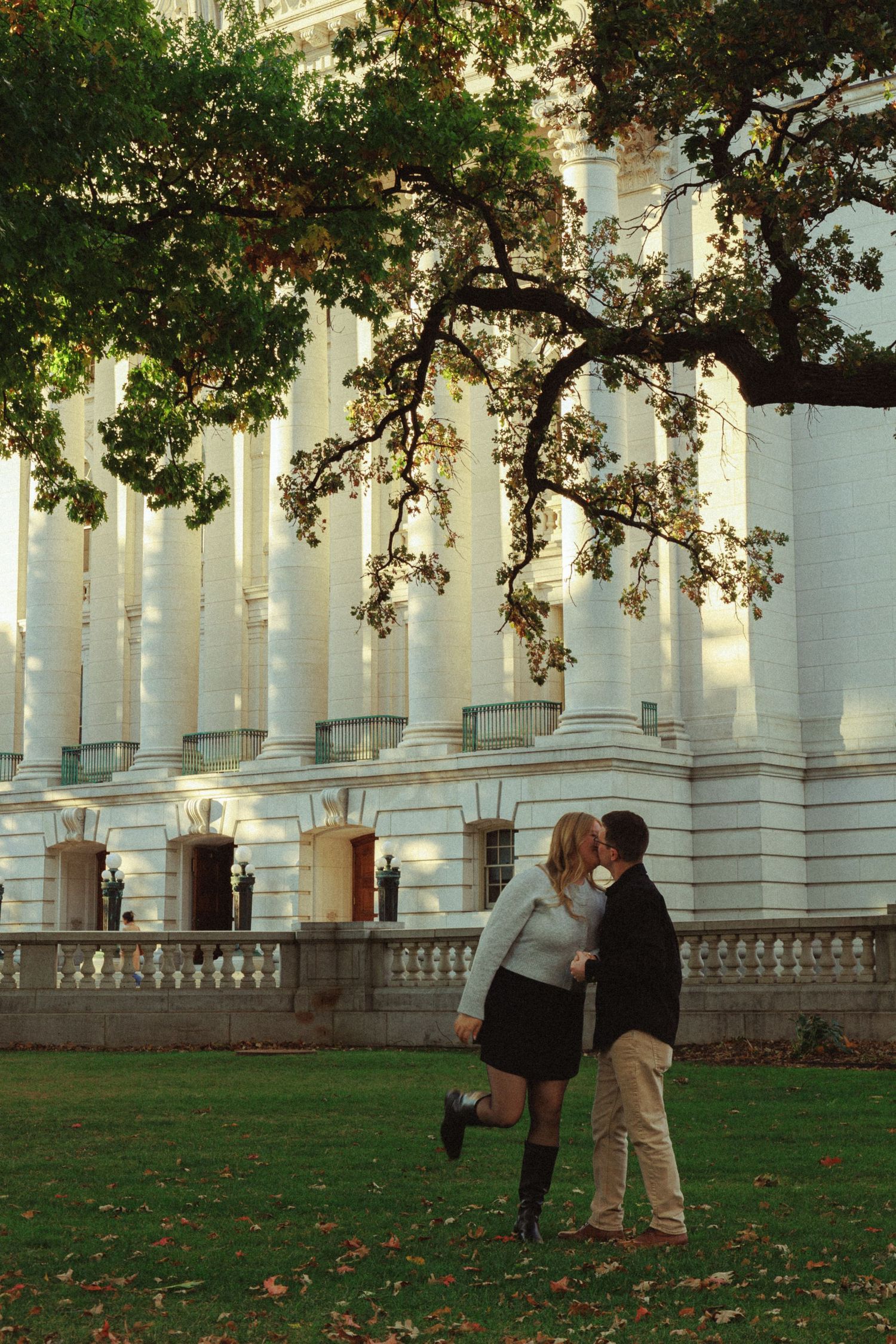 Romantic couple sharing a moment outside historic columned building.