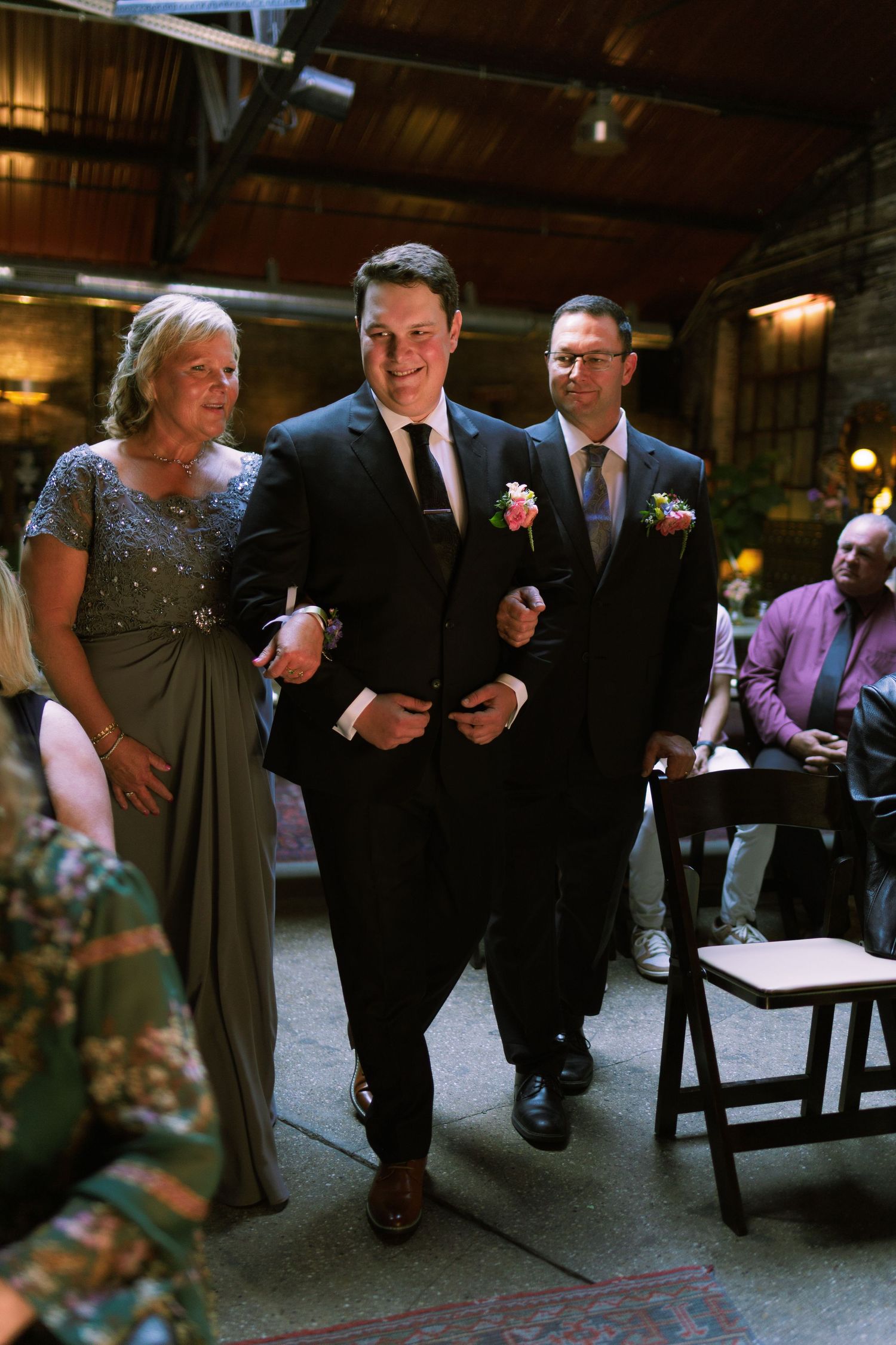 Wedding guests seated in dark venue during ceremony.