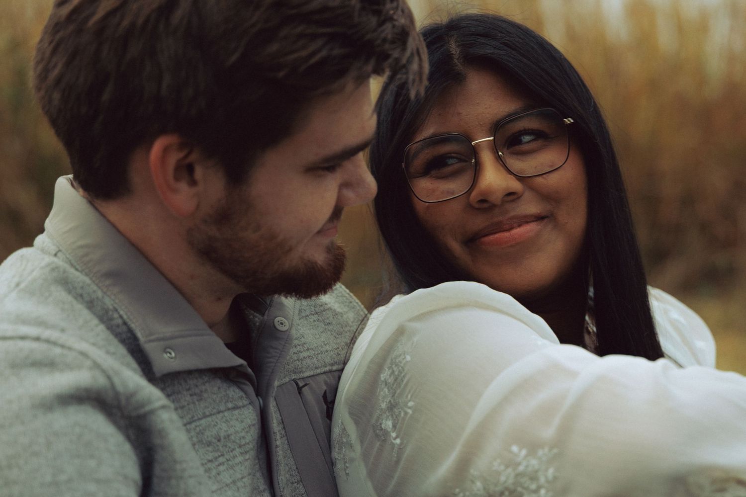 Couple sharing an intimate moment outdoors during golden hour.
