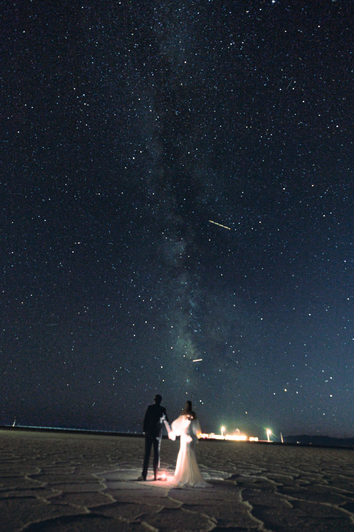 Wedding photography under a starlit sky at the Bonneville Salt Flats with dramatic nighttime lighting.