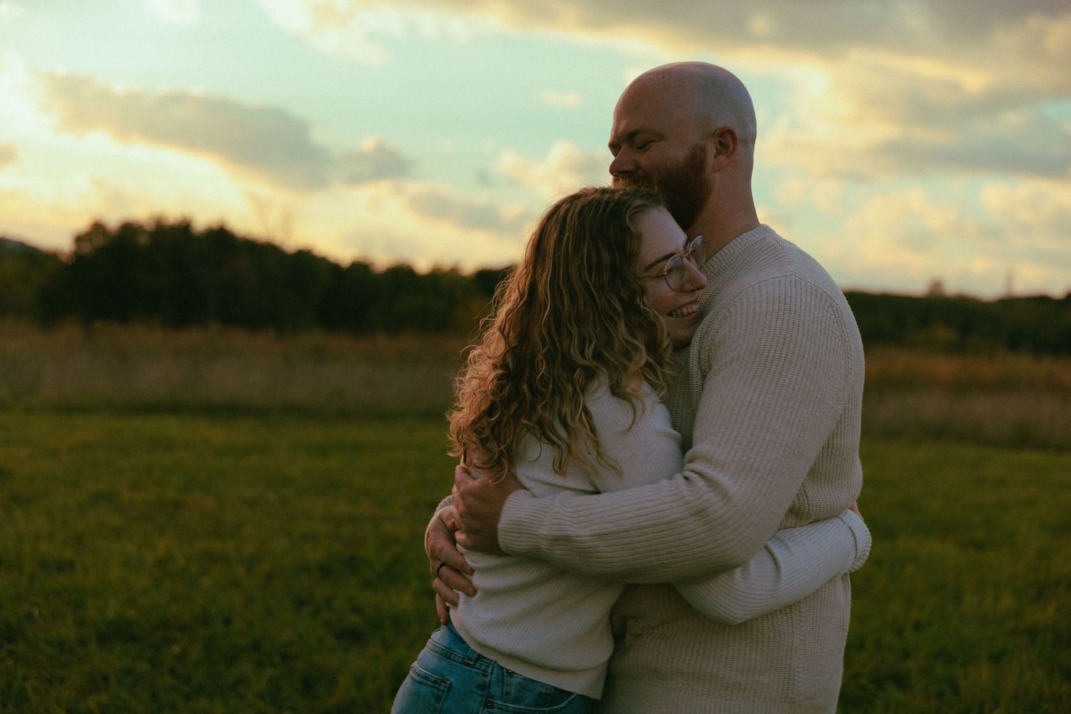 Romantic couple embracing in a golden field during sunset.