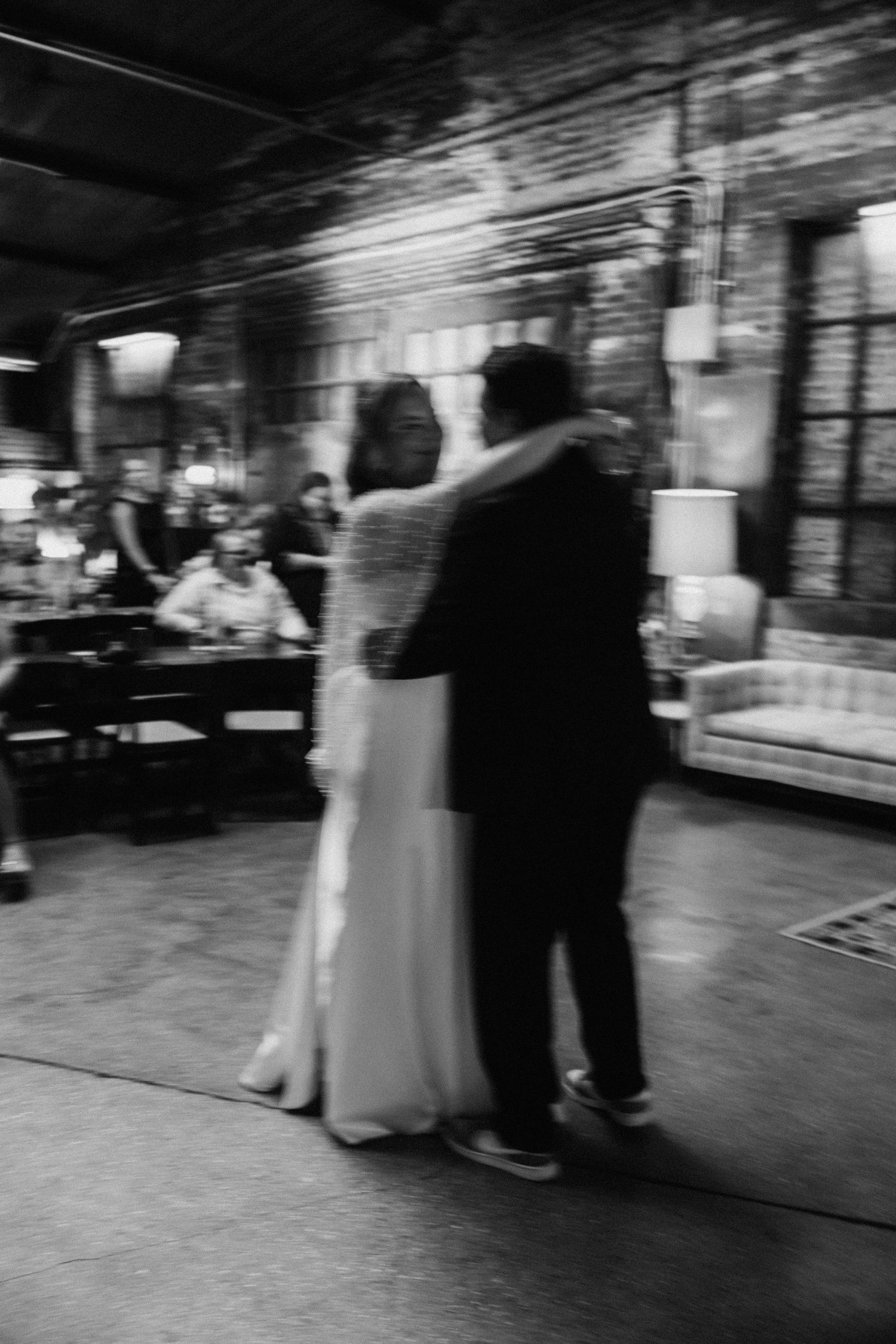 Black and white motion blur of wedding reception dance floor.