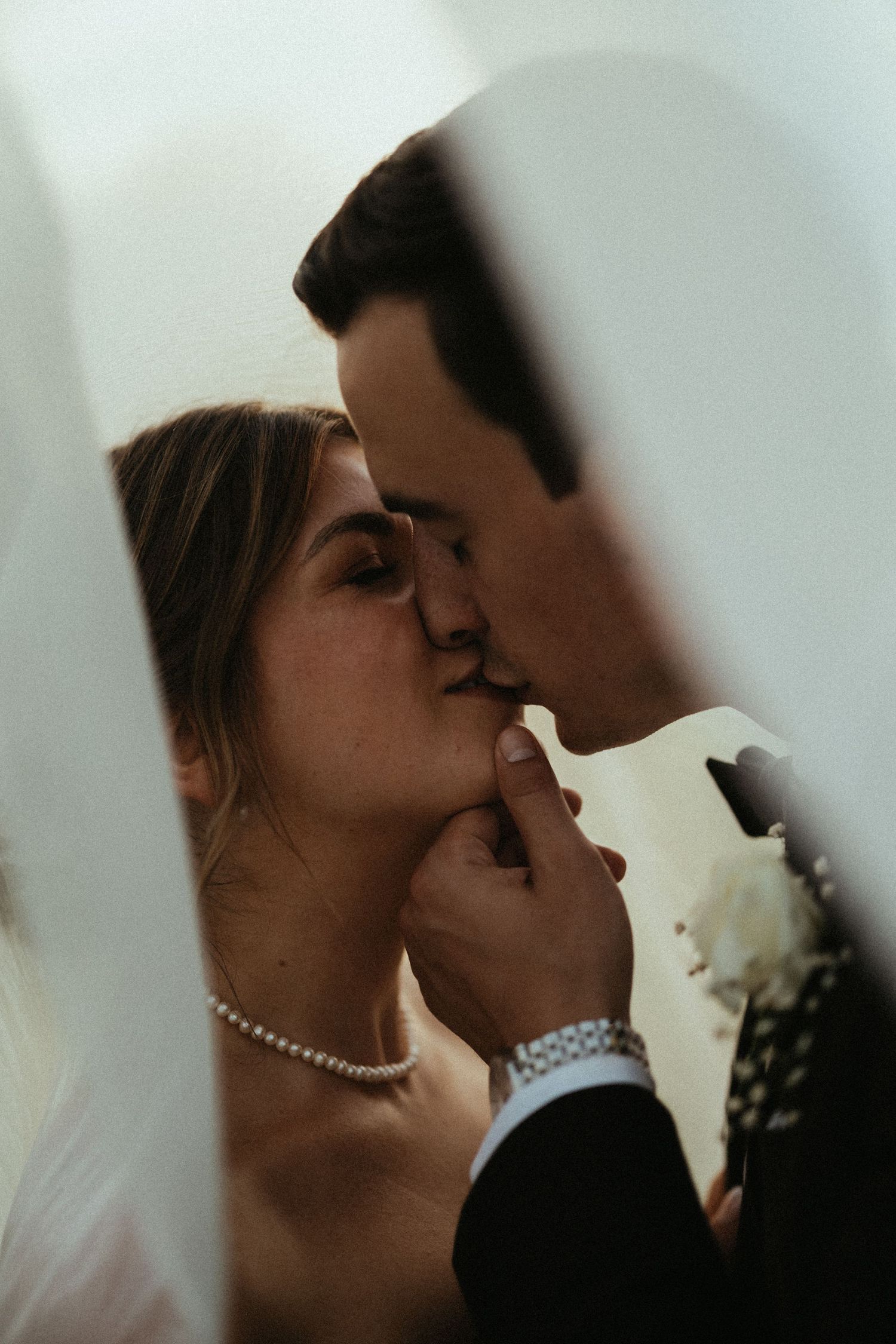 An intimate wedding portrait with soft lighting and delicate veil details.