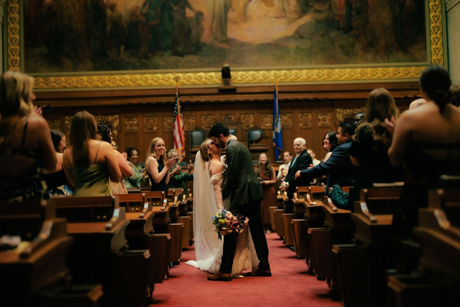 Wedding ceremony taking place in an ornate church with classical artwork and architecture.