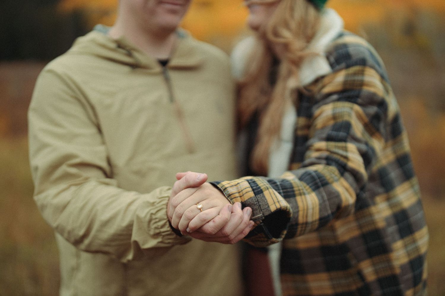 Couple walking together through a scenic mountain landscape during autumn.