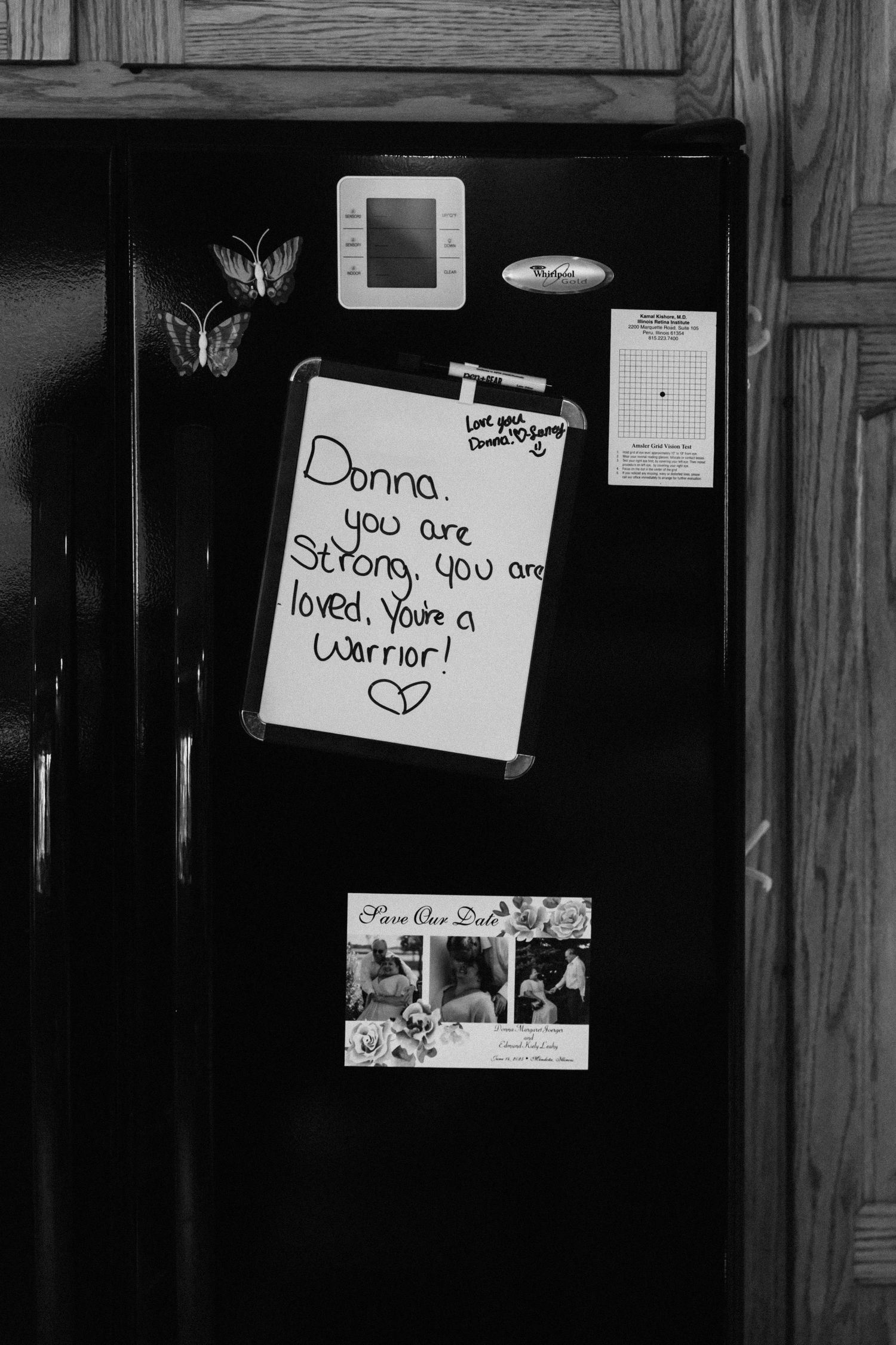 Black and white photo of handwritten love notes posted on dark wooden surface.