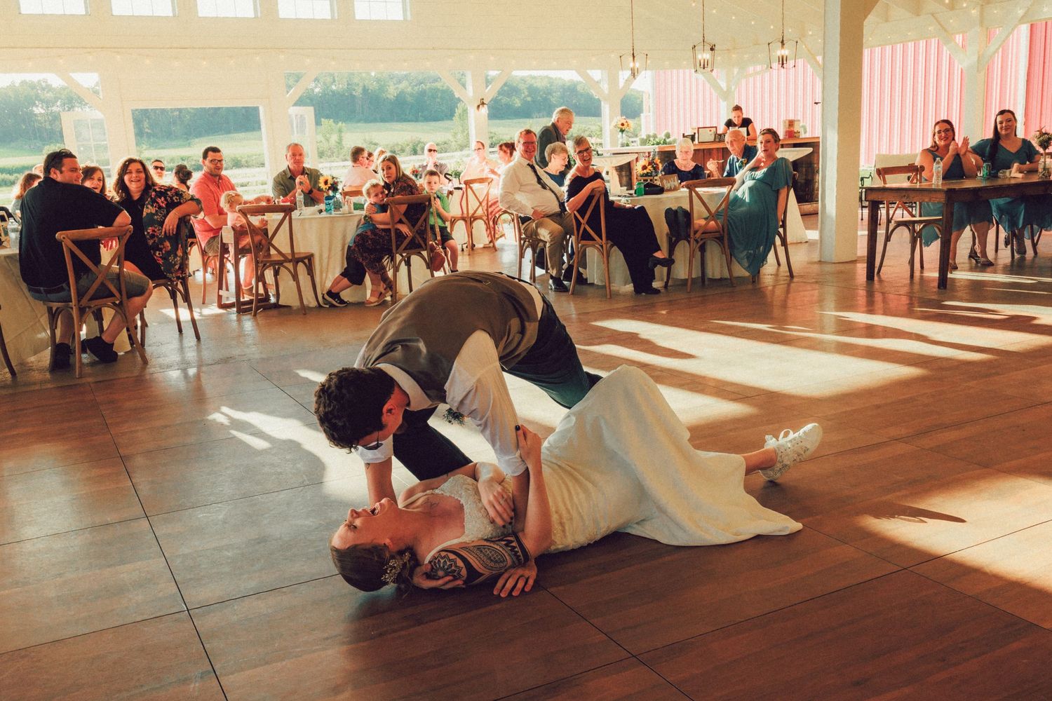 Wedding reception dance floor with guests celebrating in a sunlit venue.