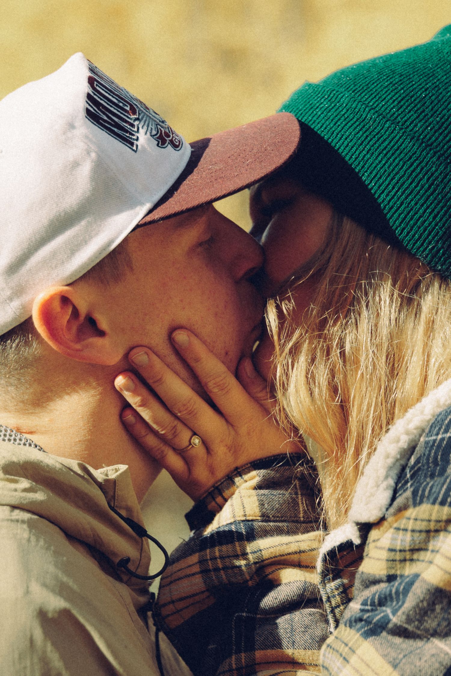 Close-up of two people sharing an intimate moment outdoors.