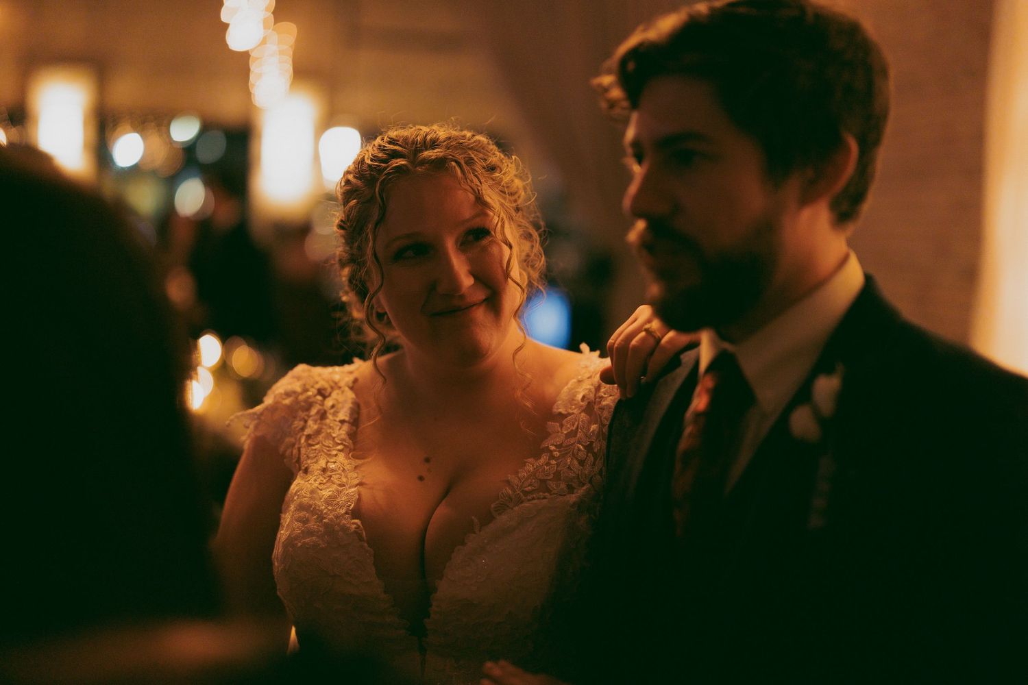 A warm-toned wedding reception scene with ambient lighting and intimate atmosphere.