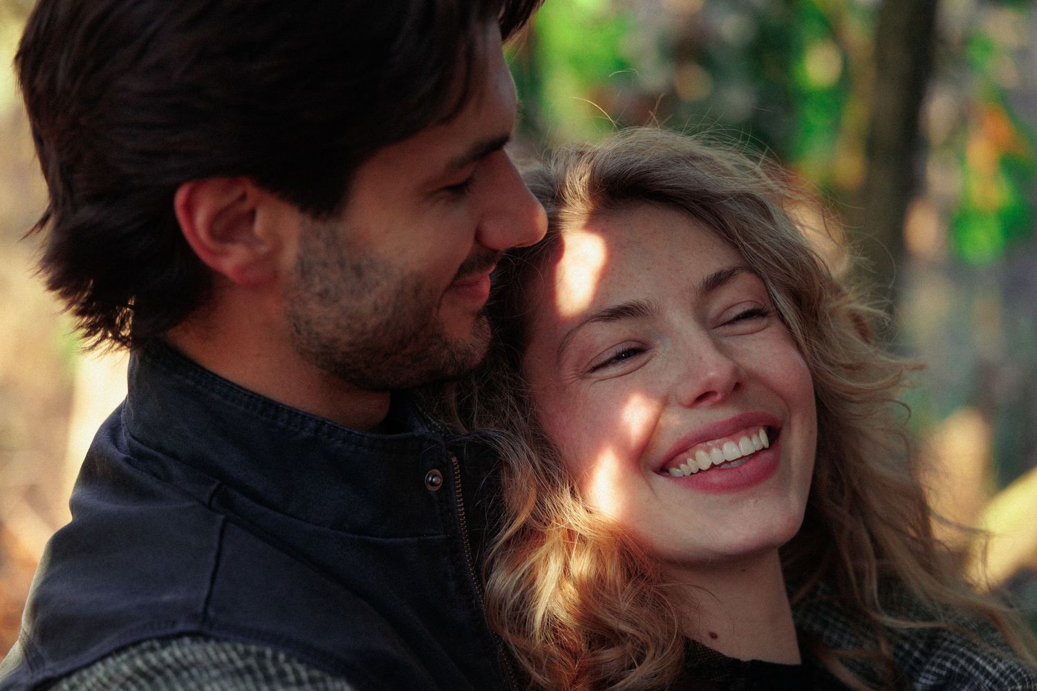 Intimate moment captured between couple in warm natural lighting outdoors.